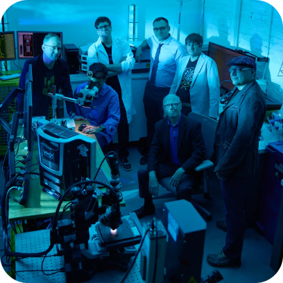group of people together in a darkly lit computer labroom.