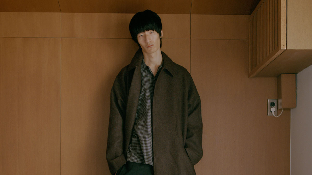 Image may contain: Son Ho-yeong, Clothing, Coat, Adult, Person, Overcoat, Fashion, Face, and Head
