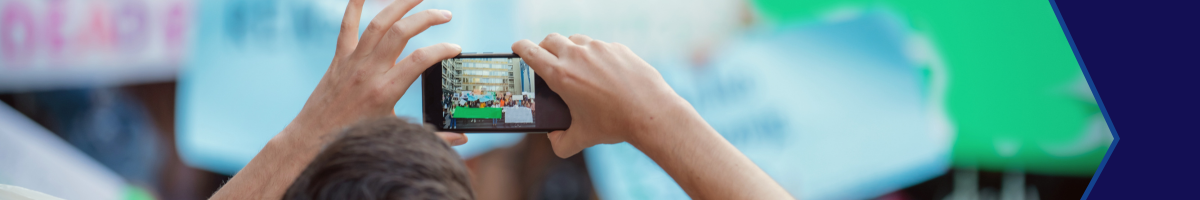 A person holding up their phone, taking a picture of a group of people.