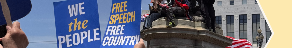 Protest signs reading We the People and Free Speech Free Country