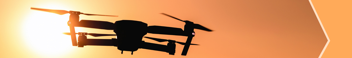 Drone flying behind sunset.