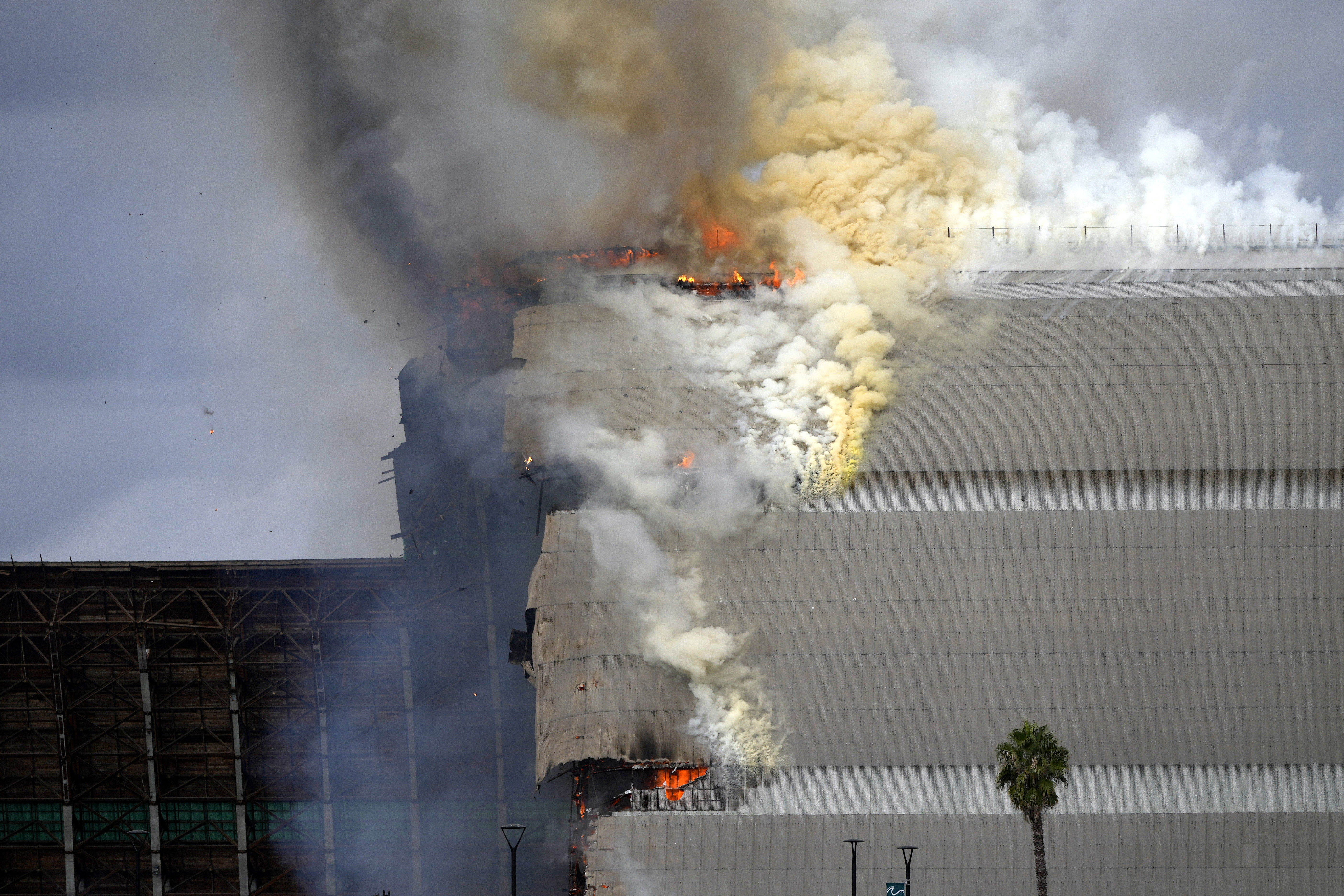 A historic blimp hangar burns in Tustin, Calif., Tuesday, Nov. 7, 2023. 