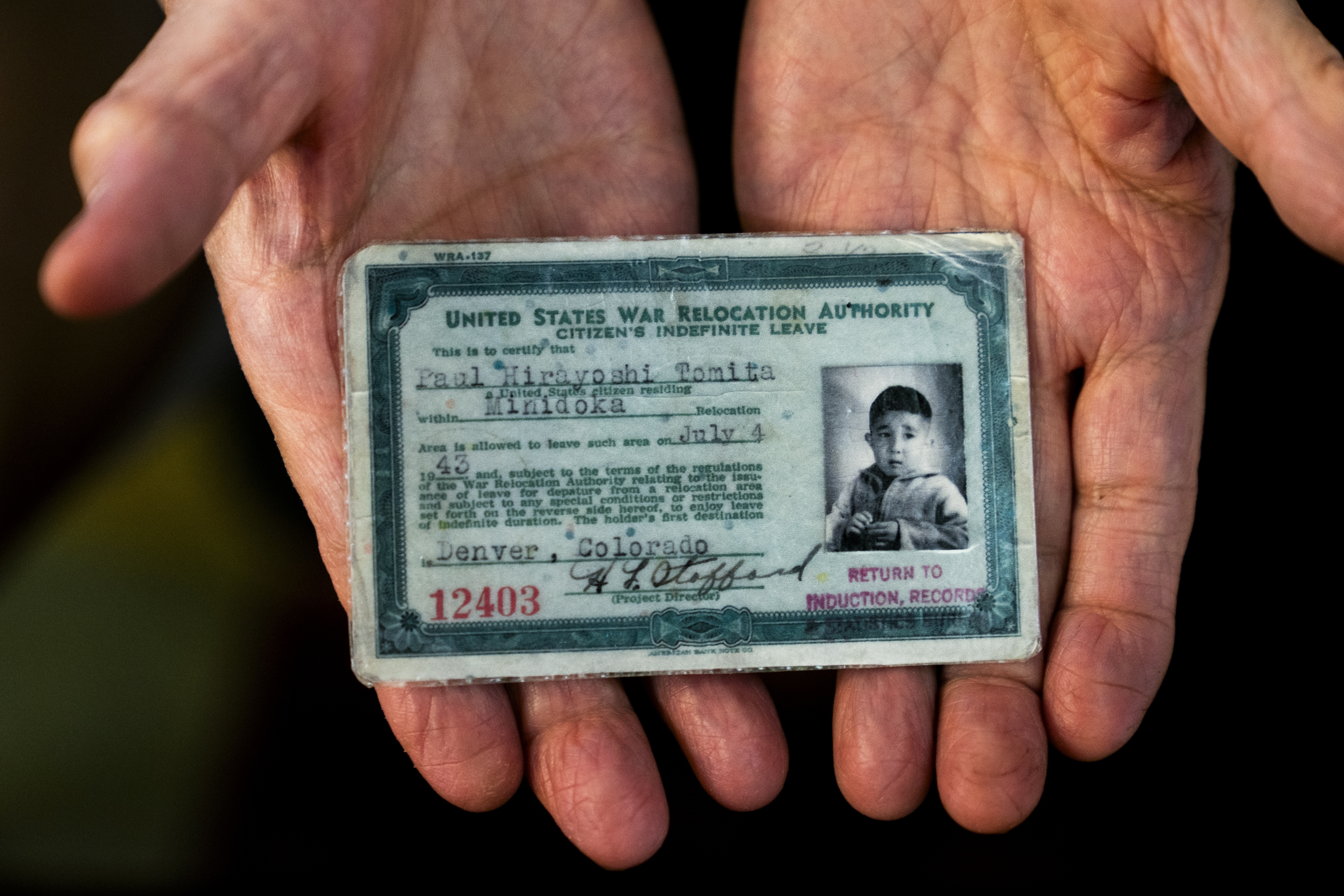 Paul Tomita displays a copy of his exit card granted to him on July 4, 1943.