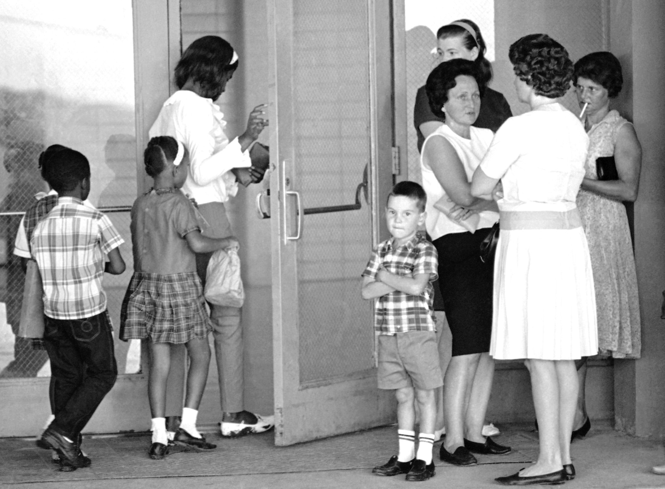 A group of African American students, left, enter the Boothville-Venice School in Plaquemines Parish, Louisiana on Sept. 12, 1966 as a group of white mothers wait at the entrance of the school. (AP Photo/Jack Thornell, file).