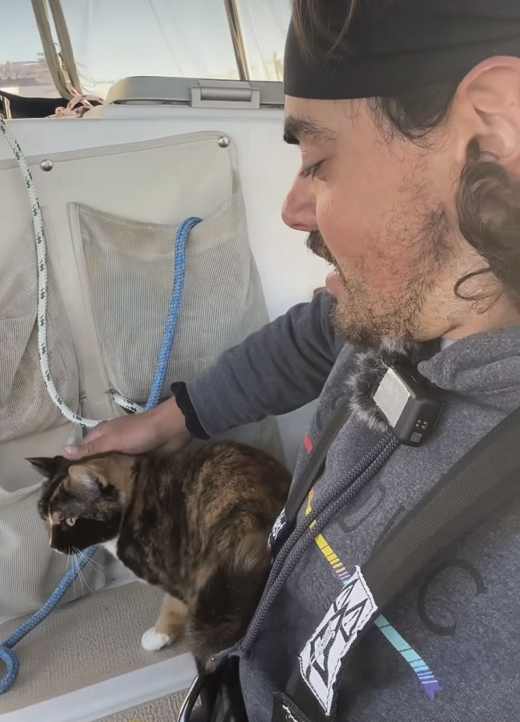 In this screengrab taken from a video posted on Oliver Widger's Instagram account May 2, Widger pets his cat, Phoenix, on their sailboat somewhere in the Pacific Ocean as both make their way from Oregon to Hawaii. (Oliver Widger via AP).