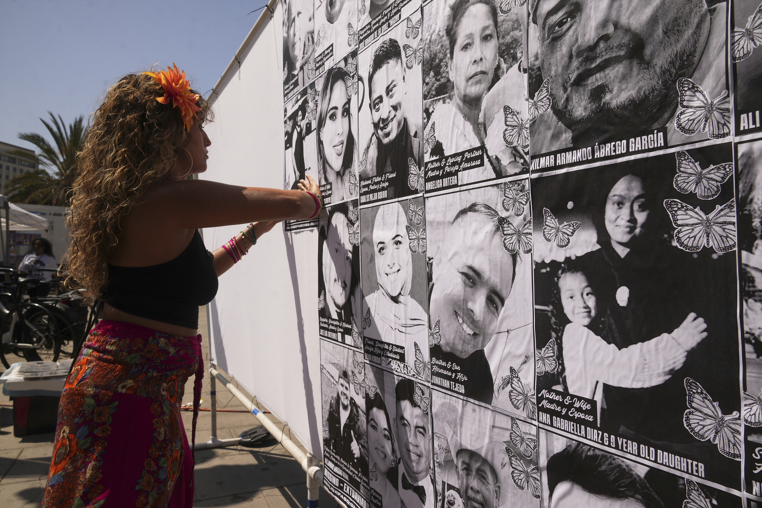 Special needs teacher Deja Nebula sets up an art installation displaying names and faces of people who have been detained, deported, or sent to offshore camps during ICE raids in Southern California, at Olvera Street Plaza in Los Angeles, on July 3. (AP Photo/Damian Dovarganes).