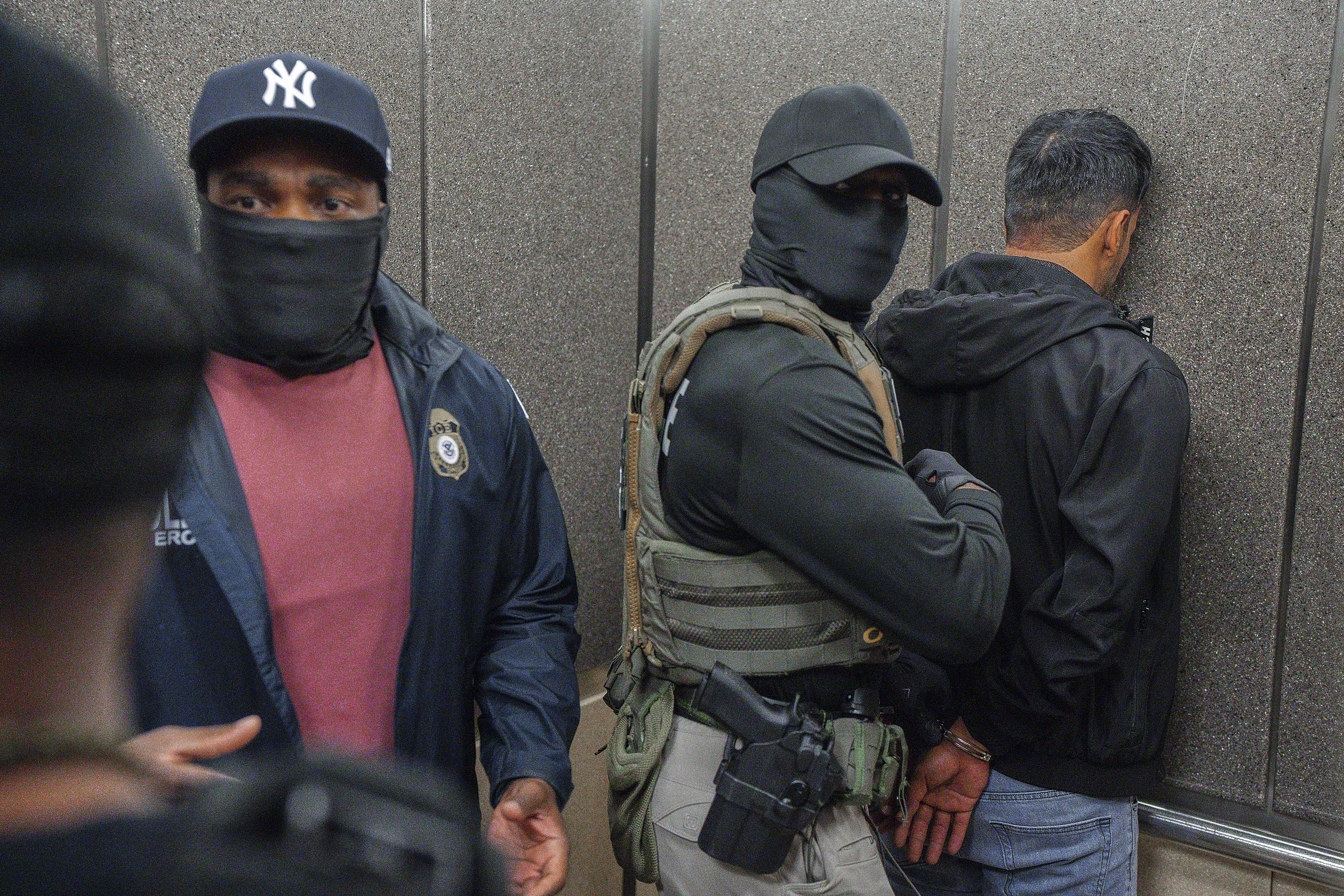Immigration and Customs Enforcement agents escort a detained immigrant into an elevator after he exited an immigration courtroom on June 17 in New York. (AP Photo/Olga Fedorova, file).