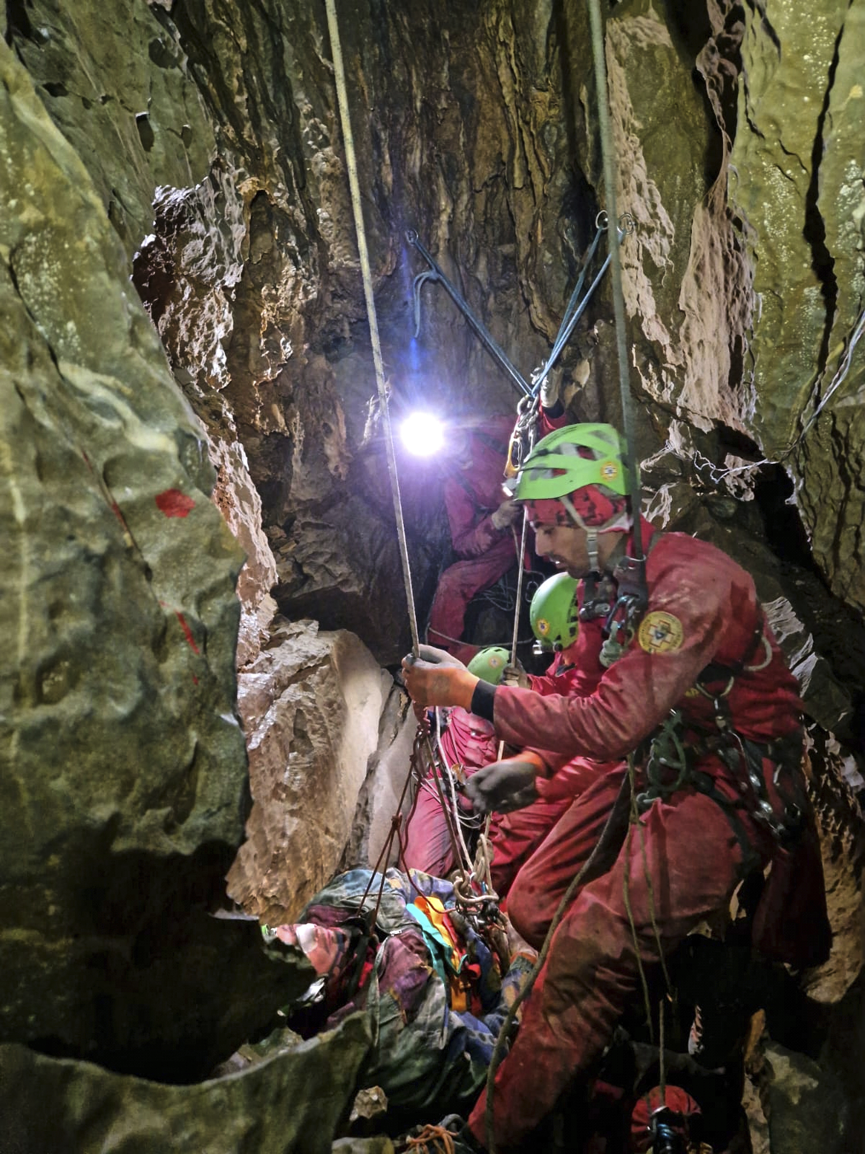 The Italian National Alpine and Speleological Rescue Corps reaches a speleologist who became trapped in a cave in northern Italy on Sunday. (National Alpine and Speleological Rescue Corps via AP)