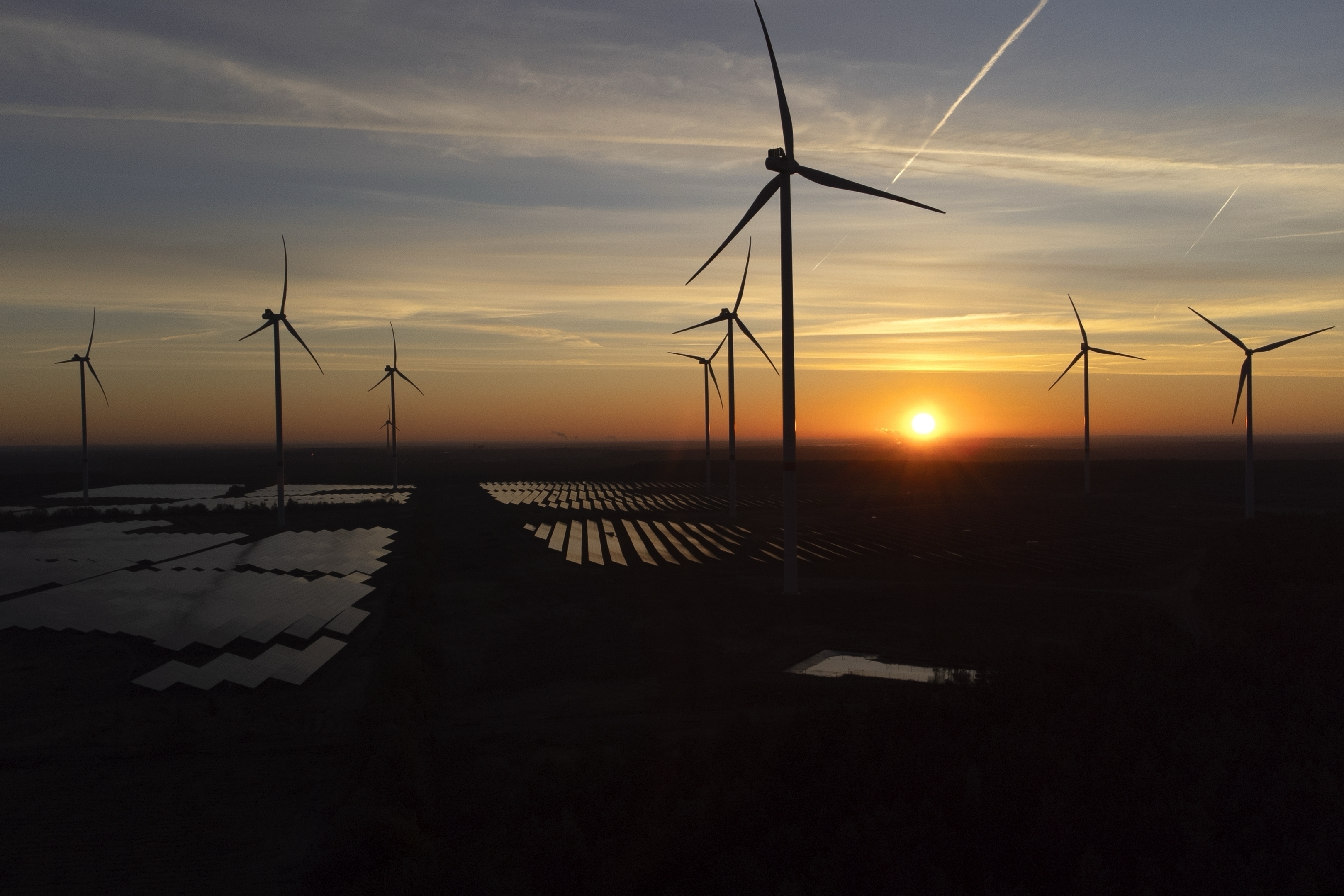 Wind turbines operate as the sun rises at the Klettwitz Nord solar energy park near Klettwitz, Germany, Oct. 16, 2024. (AP Photo/Matthias Schrader, File)