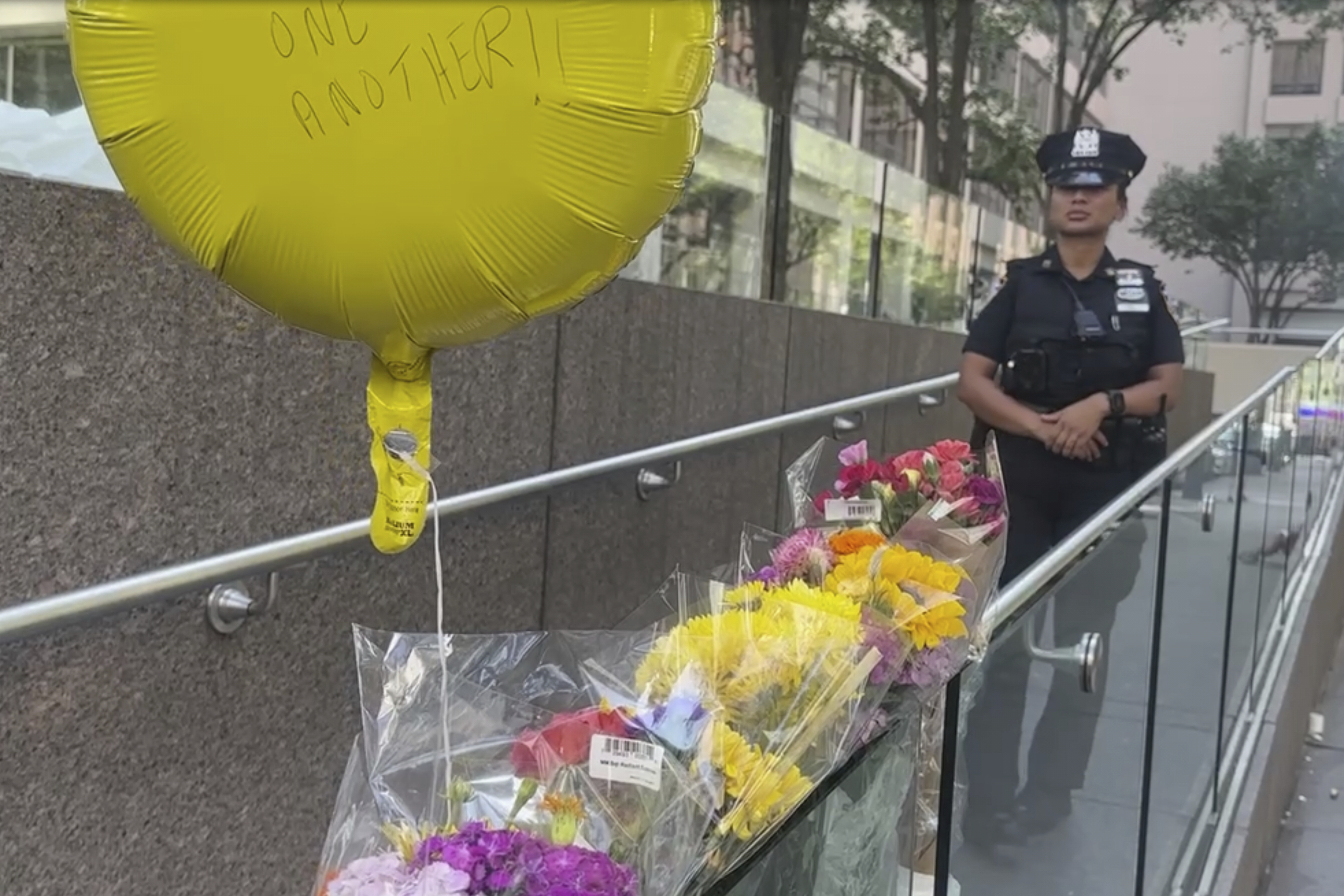A police officer stands by a make shift memorial outside scene of Monday's deadly shooting on Tuesday in New York. (AP Photo/Ted Shaffrey)