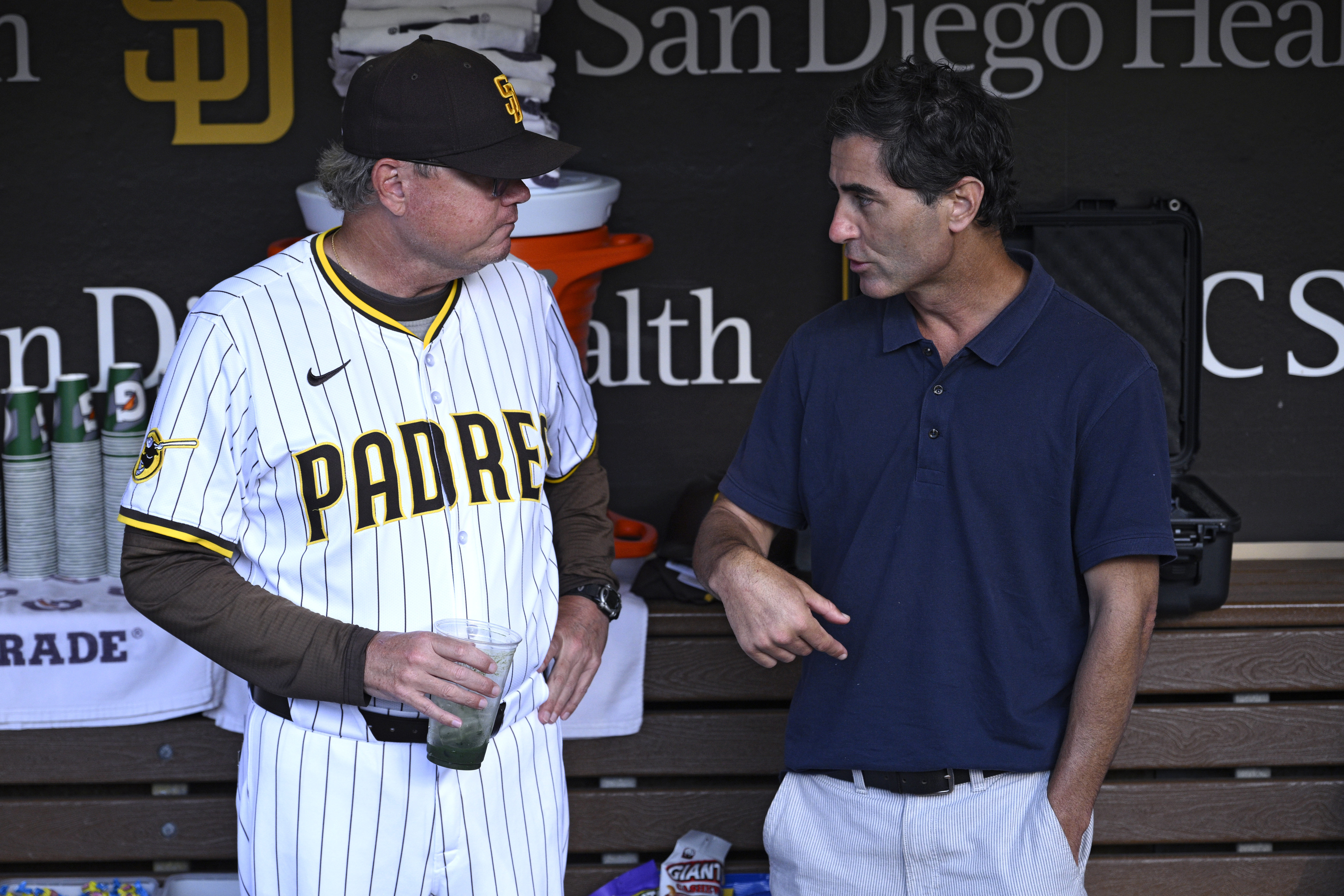 San Diego Padres manager Mike Shildt, left, and general manager A.J. Preller talk in the dugout before a baseball game against the Arizona Diamondbacks, July 8 in San Diego. (AP Photo/Orlando Ramirez).