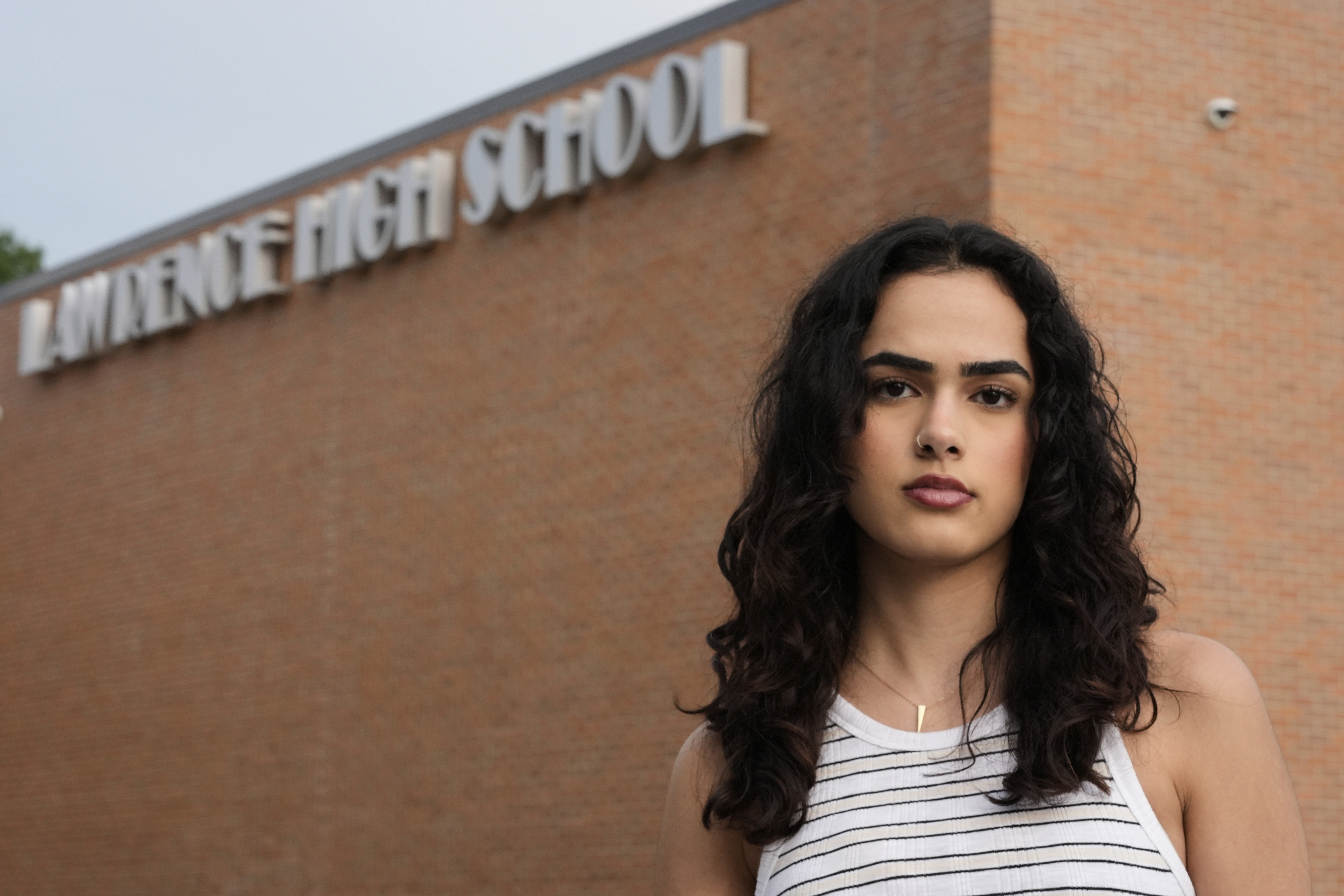 Natasha Torkzaban stands outside Lawrence High School, where she and other students have filed a lawsuit against the school district's use of digital surveillance software, Sunday in Lawrence, Kan. (AP Photo/Charlie Riedel)