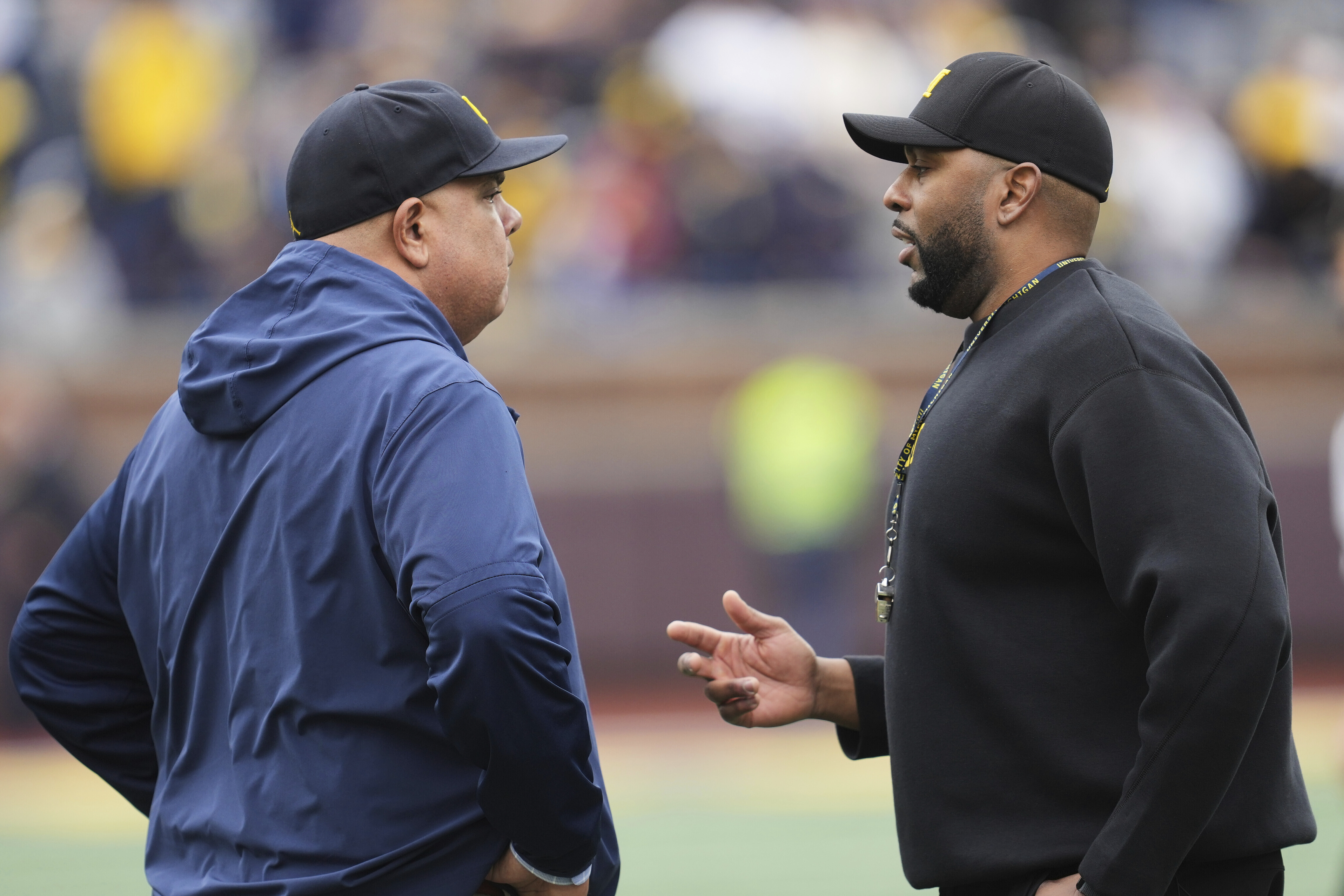 Michigan athletic director Warde Manuel, left, talks with head coach Sherrone Moore, right, before an NCAA college football spring game in Ann Arbor, Mich. in April. (AP Photo/Paul Sancya).
