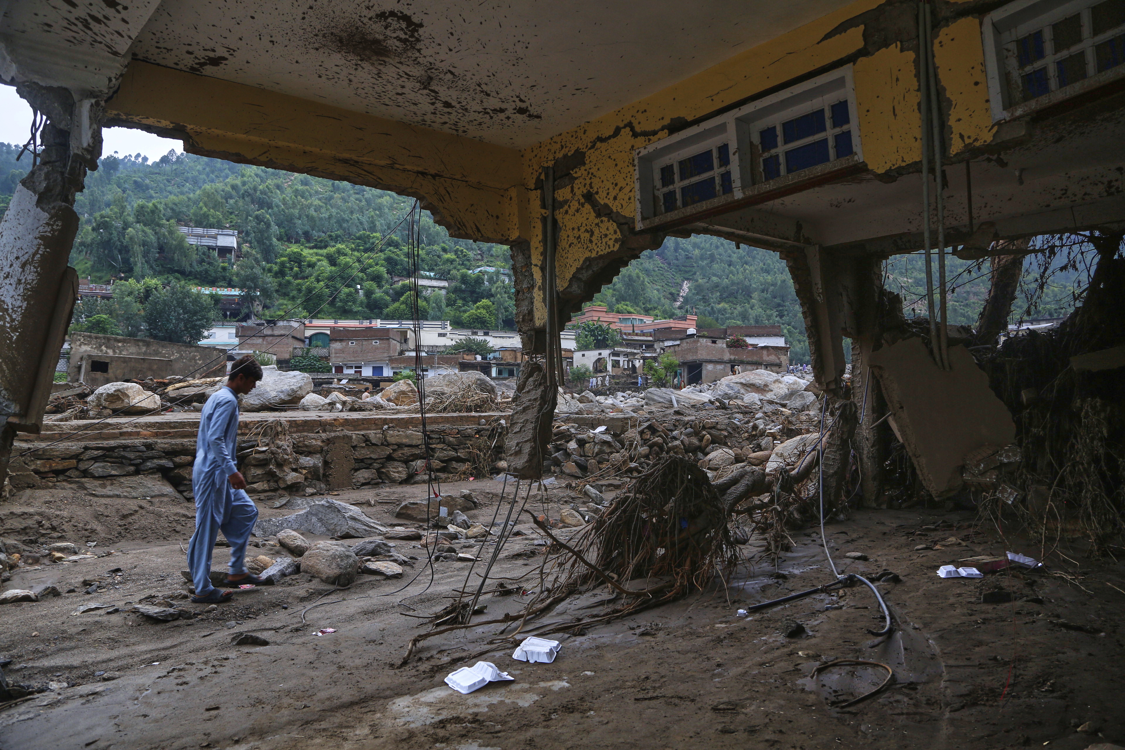 A local resident looks a damaged home following Friday's flash flooding at a neighborhood of Pir Baba, an area of Buner district, in Pakistan's northwest, Sunday. (AP Photo/Muhammad Sajjad)