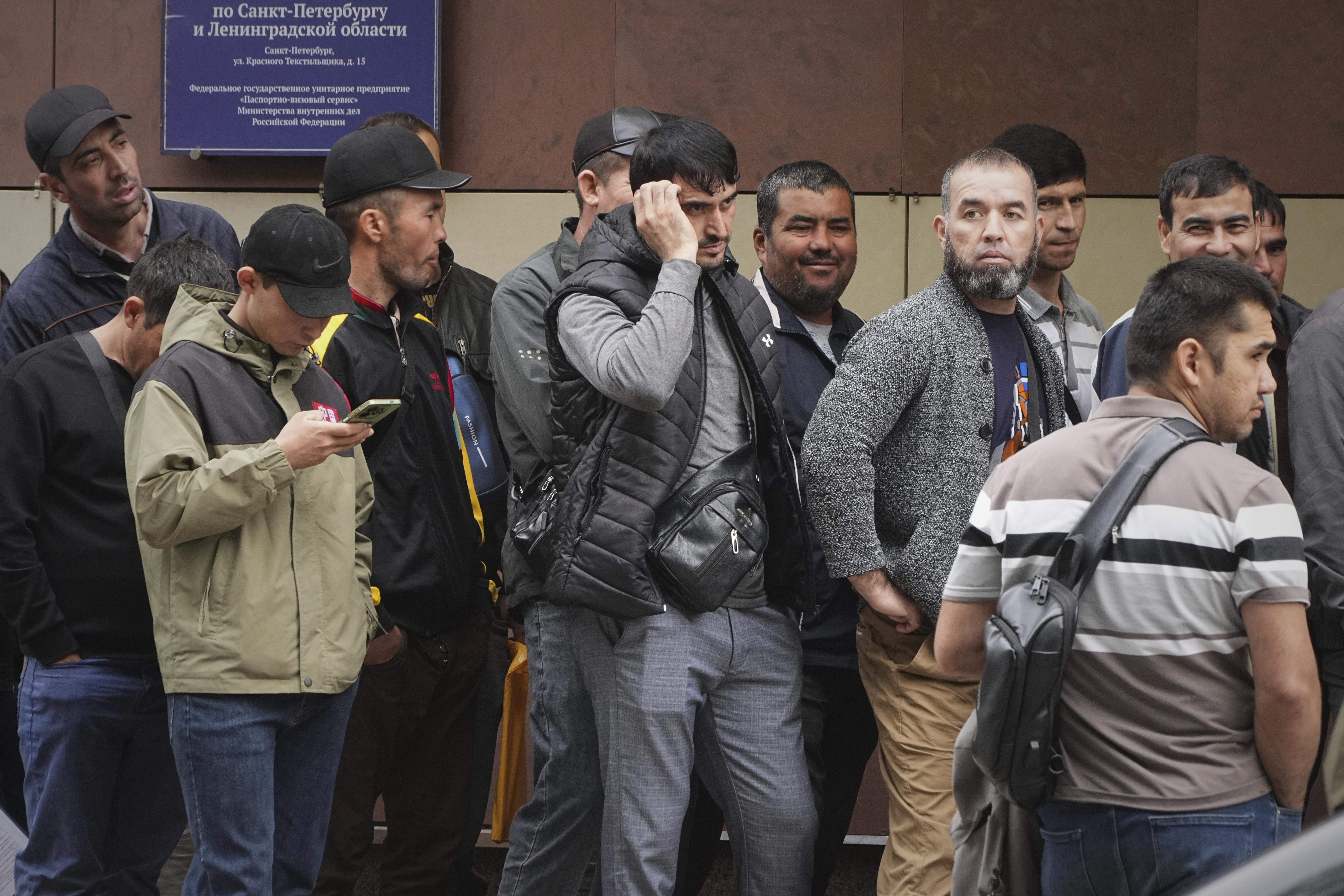 People stand in line to enter a center for government services in St. Petersburg, Russia, on Aug. 11. (AP Photo/Dmitri Lovetsky).