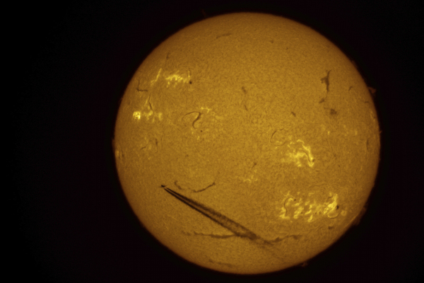 An airliner is silhouetted against the sun over St. Petersburg
