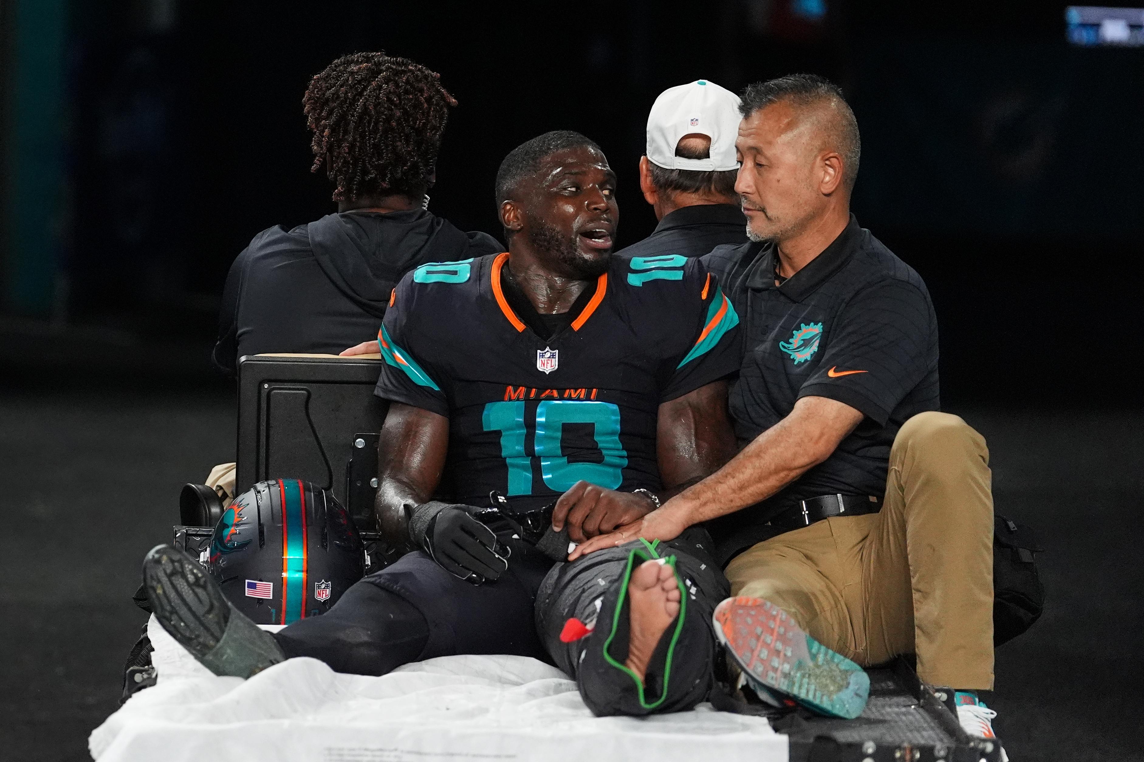 Miami Dolphins wide receiver Tyreek Hill (10) talks with a staff member as he is carted off the field after suffering an unknown lower leg injury in the second half of an NFL football game against the New York Jets, Monday, Sept. 29, 2025, in Miami Gardens, Fla. (AP Photo/Rebecca Blackwell)