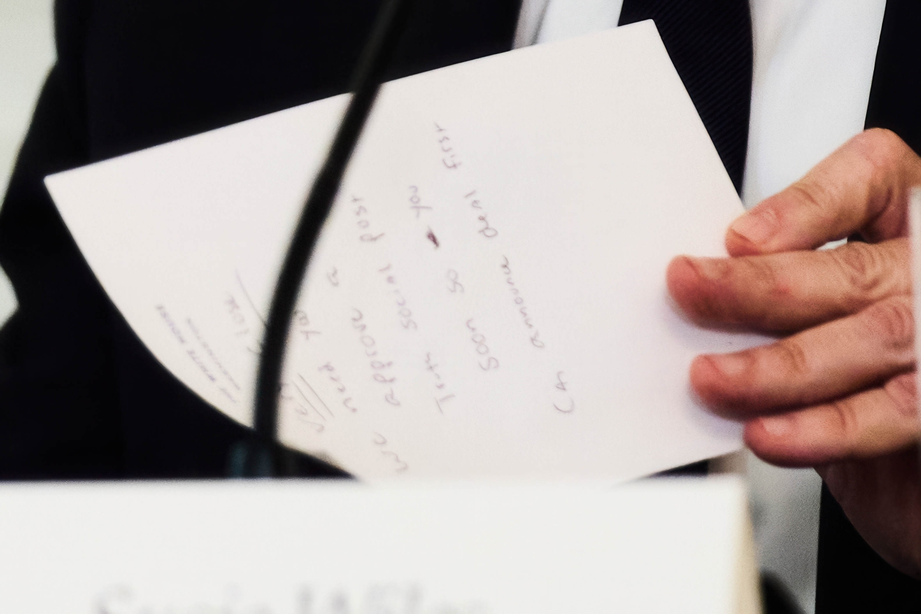 Secretary of State Marco Rubio writes a note before handing it to President Donald Trump at the White House