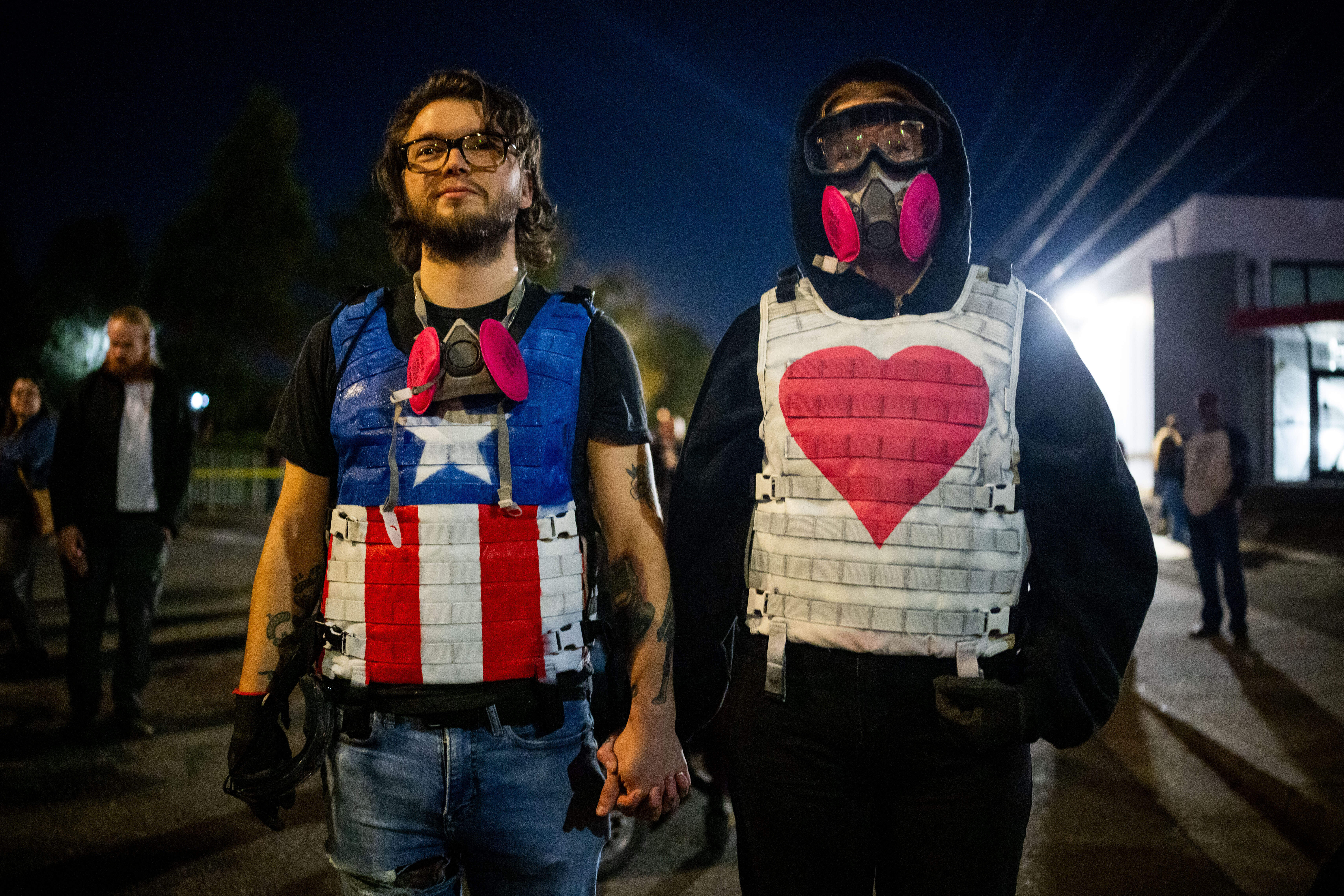 People relax on a street outside a U.S. Immigration and Customs Enforcement facility in Portland