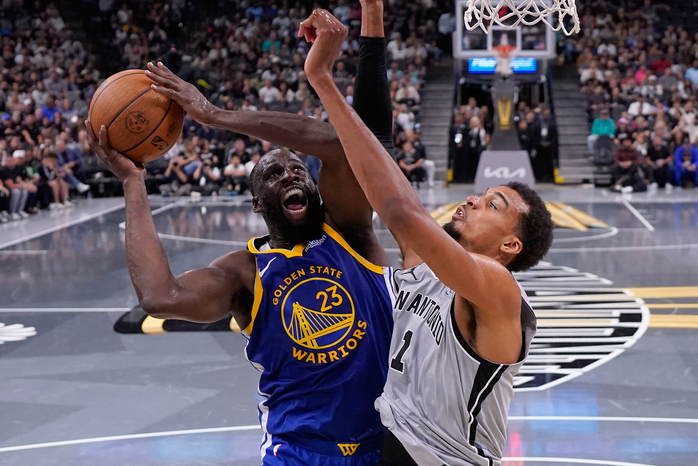 Golden State Warriors forward Draymond Green (23) drives to the basket against San Antonio Spurs forward Victor Wembanyama (1) during the second half of an NBA Cup basketball game in San Antonio, Nov. 14. (AP Photo/Eric Gay).