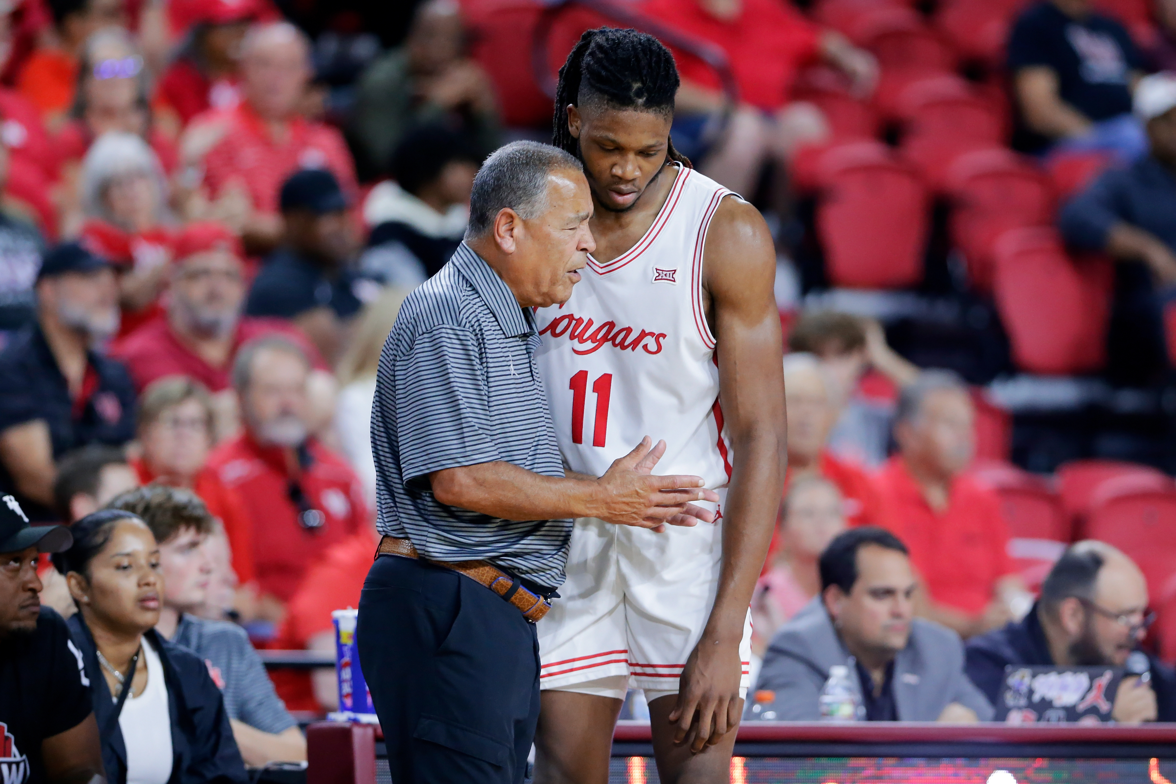Houston head coach Kelvin Sampson, left, talks with forward Joseph Tugler (11) at the bench during the second half of an NCAA college basketball exhibition game against Mississippi State, Sunday, Oct. 26, 2025, in Rosenberg, Texas.