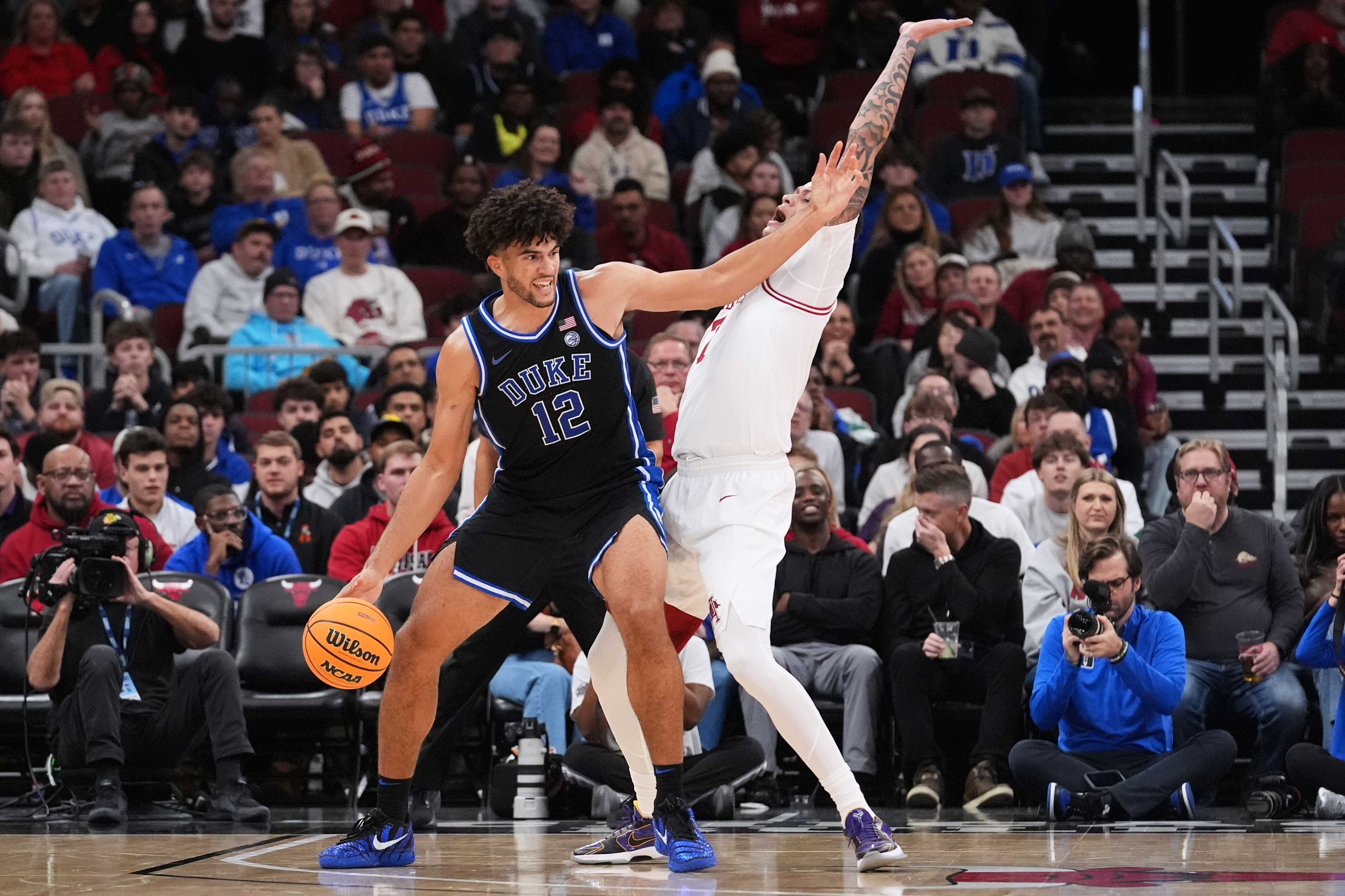 Duke forward Cameron Boozer, left, drives against Arkansas forward Trevon Brazile, right, during the second half of an NCAA college basketball game in the CBS Sports Thanksgiving Classic tournament Thursday, Nov. 27, 2025, in Chicago. (AP Photo/Nam Y. Huh)