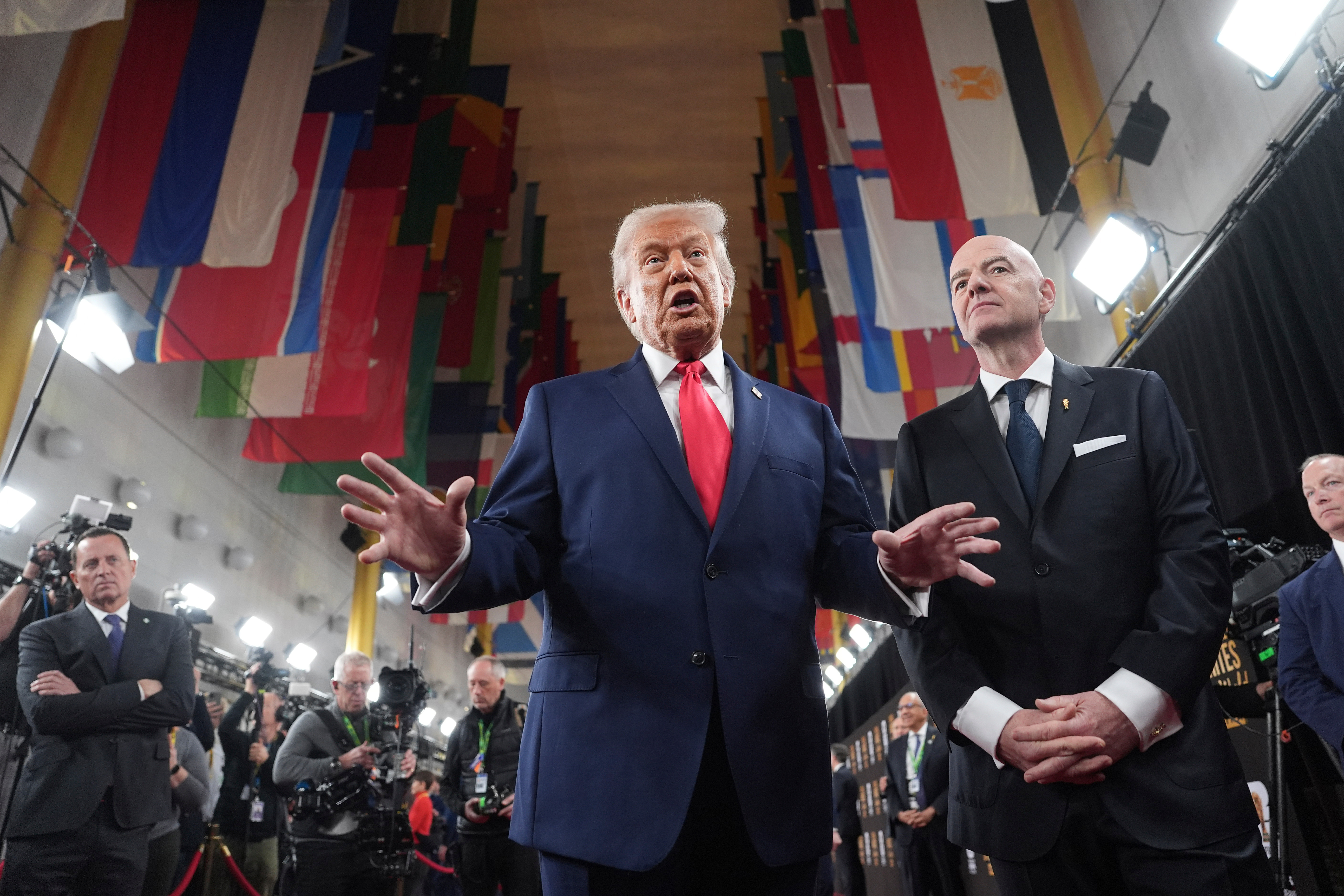 President Donald Trump, center, speaking to members of the media during his arrival with FIFA President Gianni Infantino, right, at the Kennedy Center for the 2026 FIFA World Cup draw, Friday, Dec. 5, 2025, in Washington.