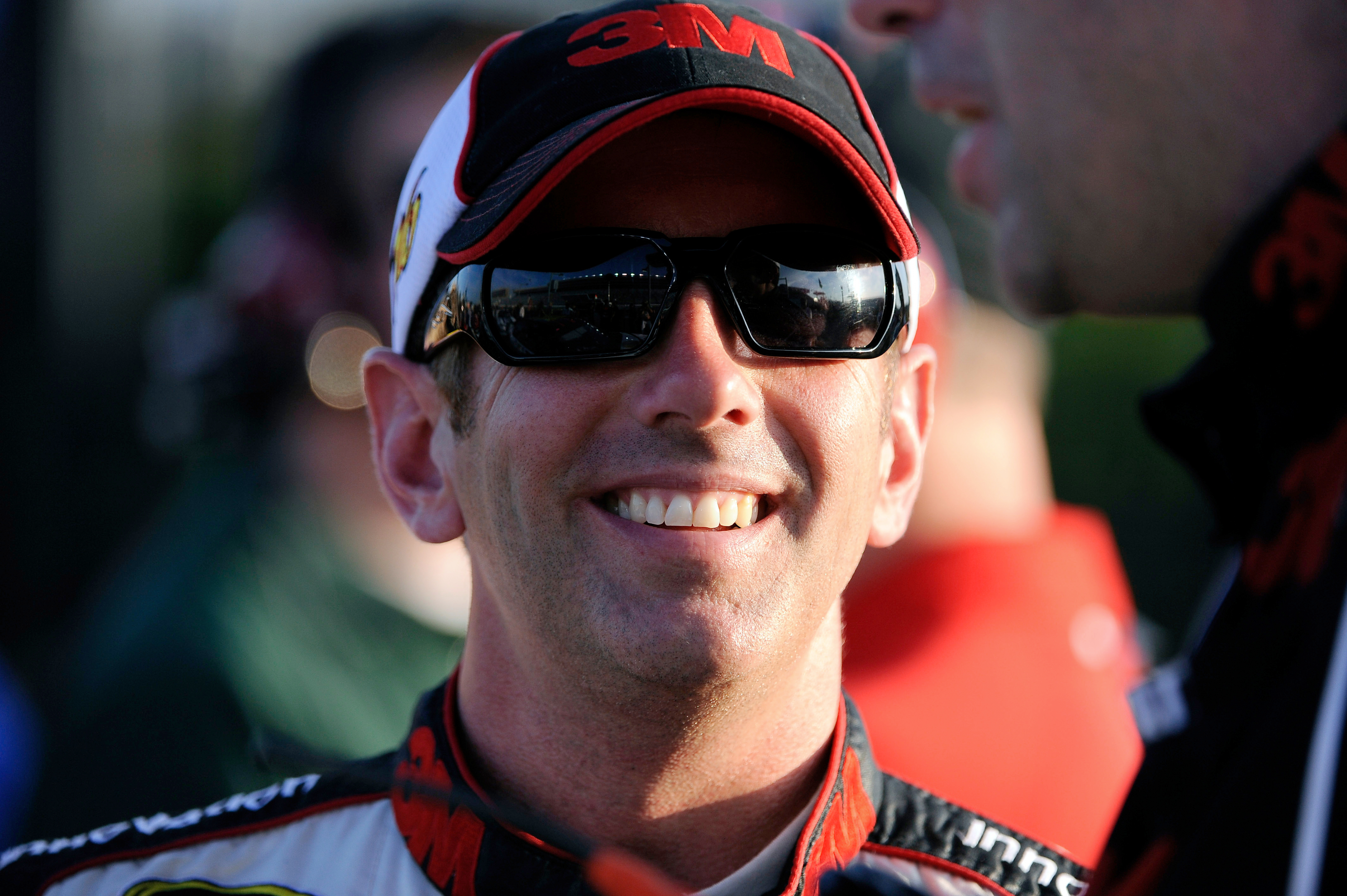 Greg Biffle smiles along pit row during qualifying NASCAR Sprint Cup Series auto race at Atlanta Motor Speedway in 2012, in Hampton, Ga. (AP Photo/David Tulis).