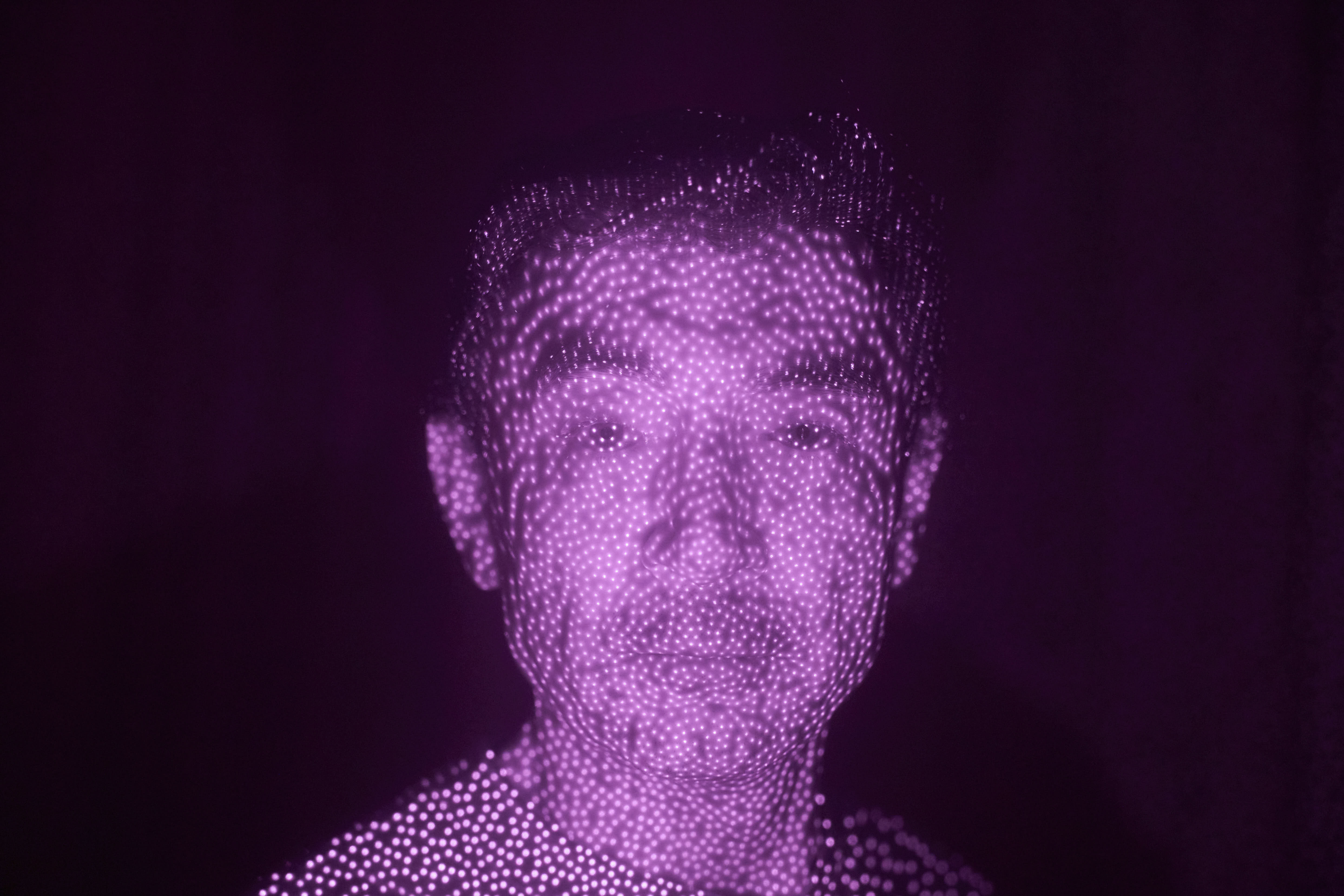 Former Xinjiang government engineer Nureli Abliz is illuminated by cellphone infrared facial recognition beams in Mannheim, Germany. 