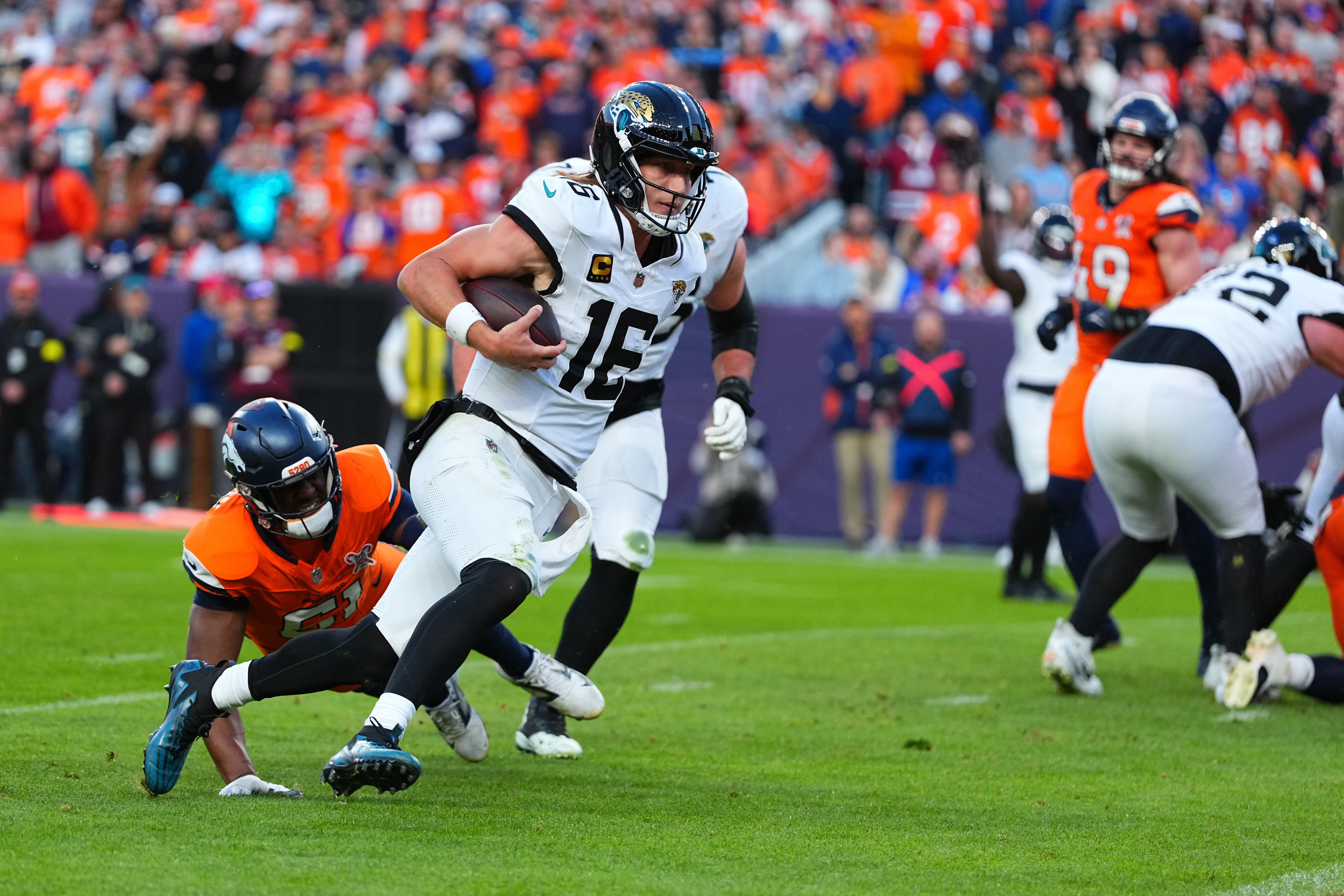 Jacksonville Jaguars quarterback Trevor Lawrence (16) runs with the ball during the second half of an NFL football game against the Denver Broncos in Denver, Sunday, Dec. 21, 2025.