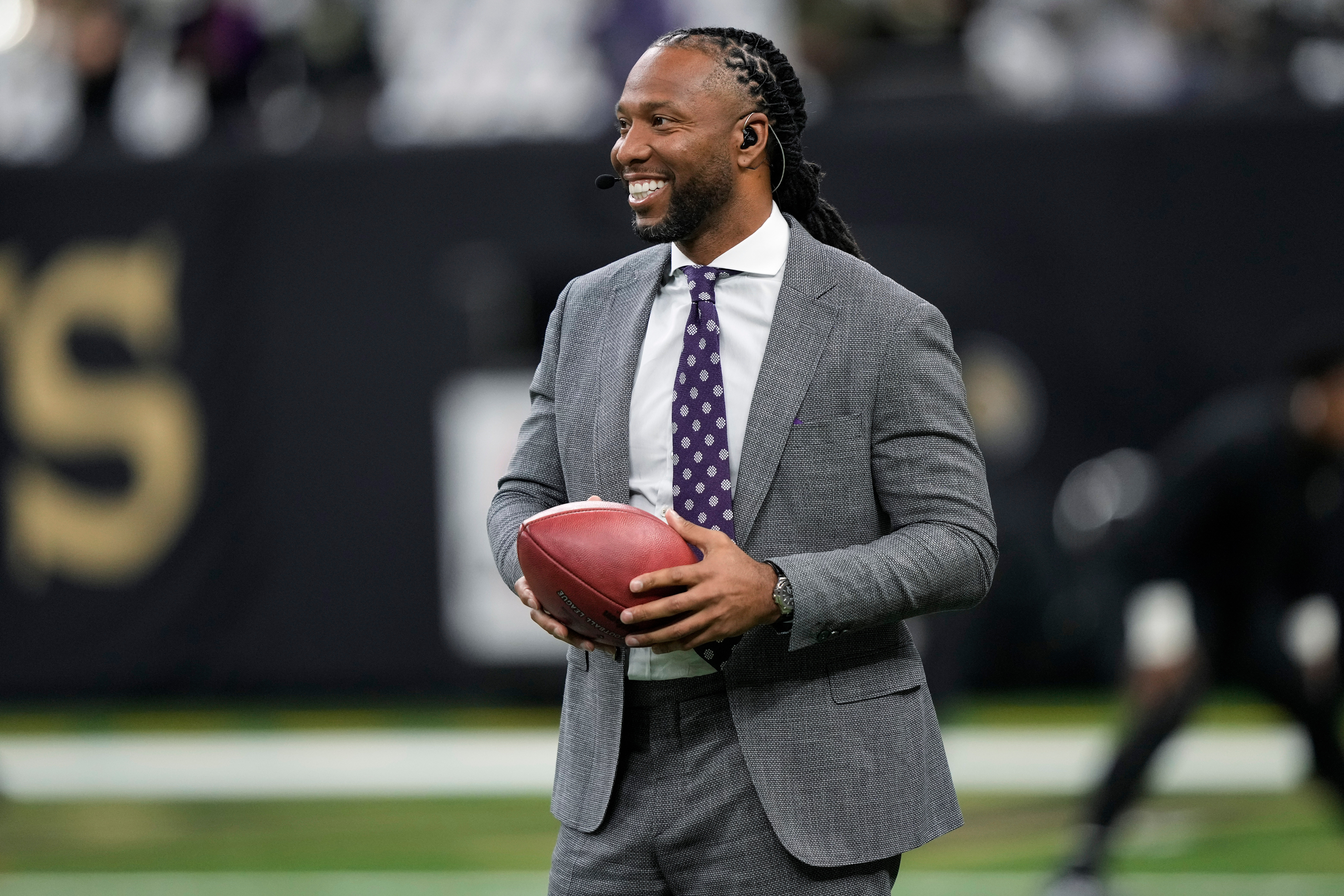 FILE - Larry Fitzgerald Jr. holds a ball on the field before an NFL football game between the New Orleans Saints and the Baltimore Ravens in New Orleans on Nov. 7, 2022.