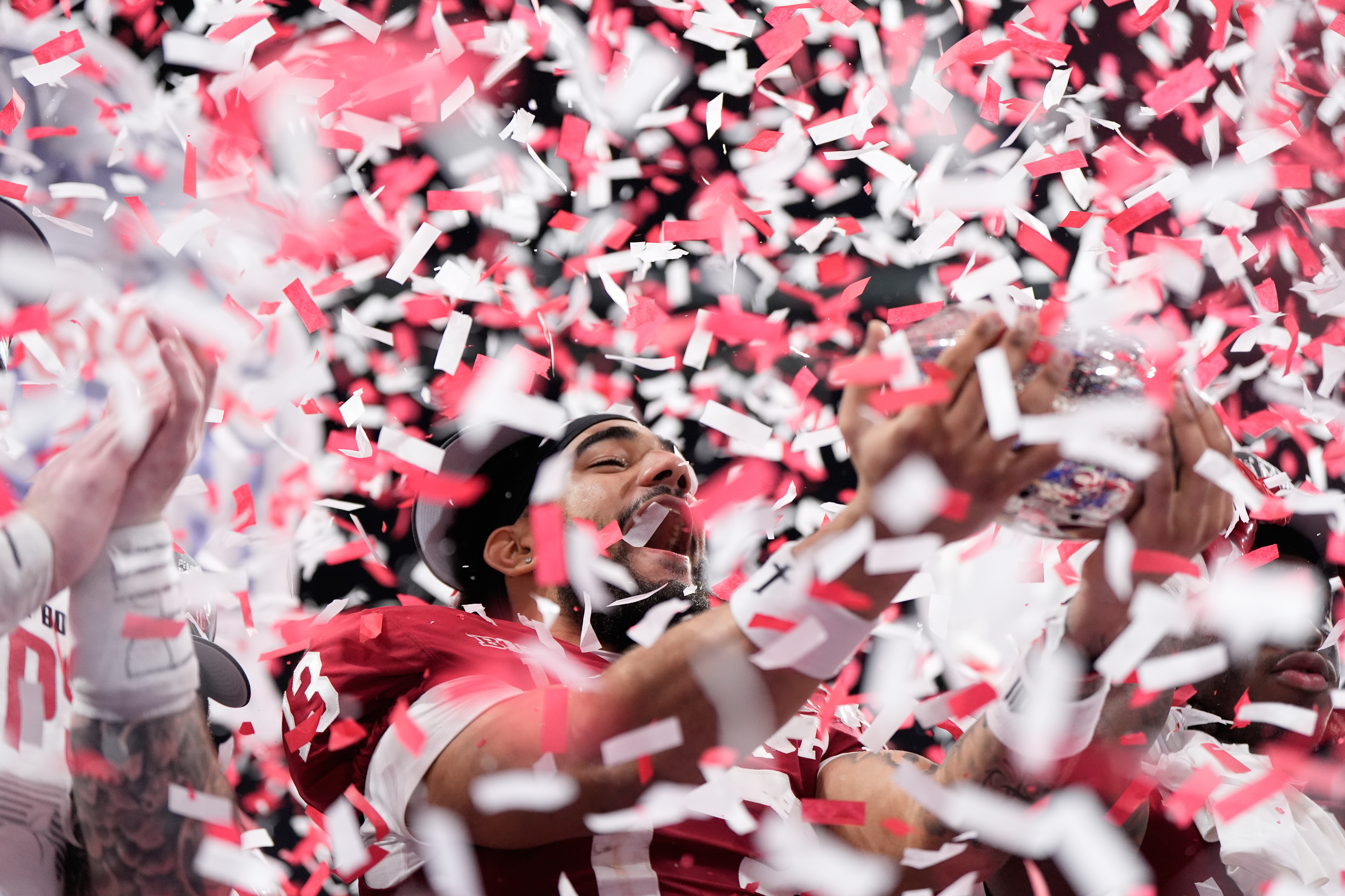 Indiana wide receiver Elijah Sarratt (13) holds up the trophy after the Peach Bowl NCAA college football playoff semifinal against Oregon, Friday, Jan. 9, 2026, in Atlanta.