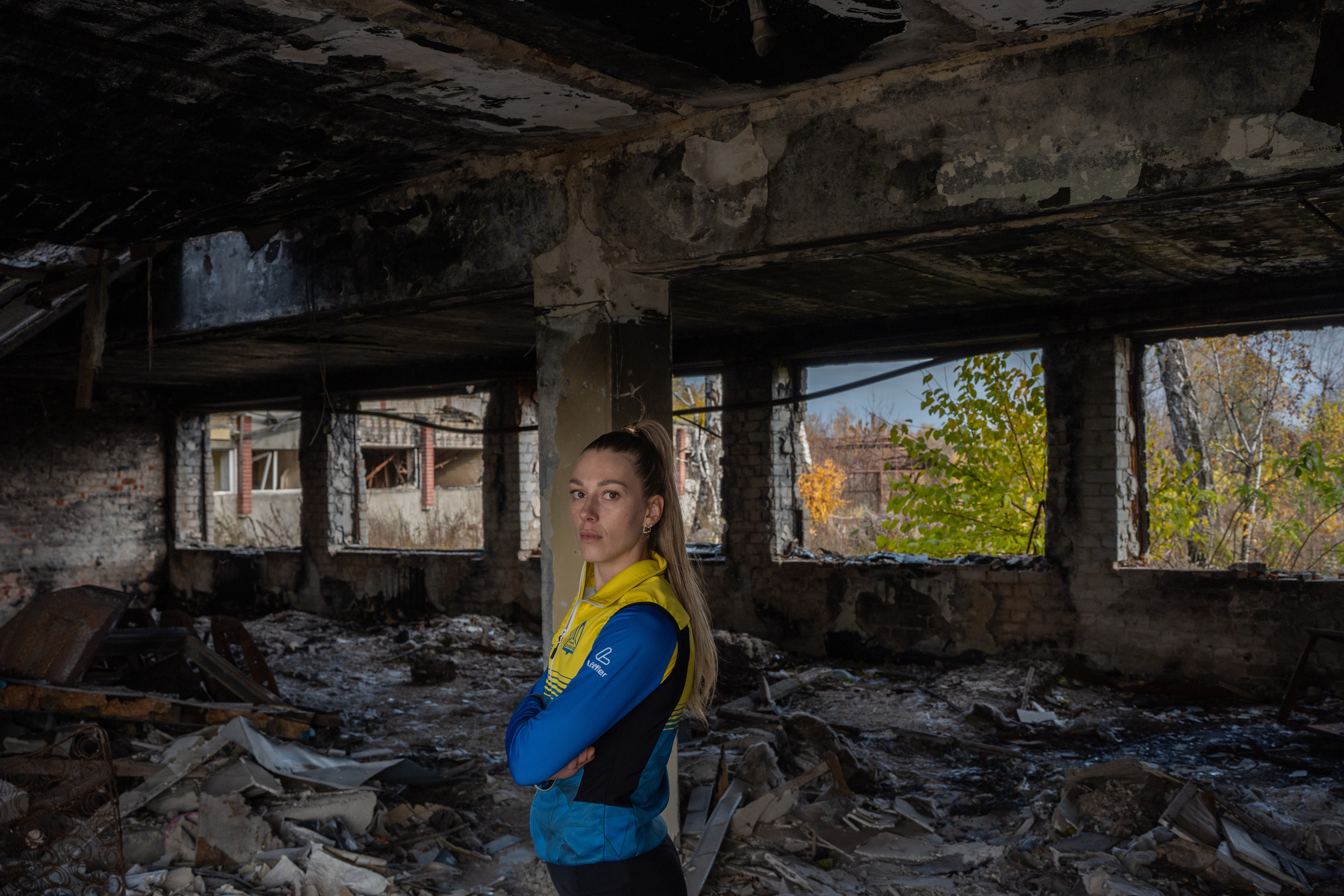 Biathlete Khrystyna Dmytrenko poses for photos inside the destroyed ski base in Chernihiv, Ukraine, Thursday, Oct. 30, 2025.