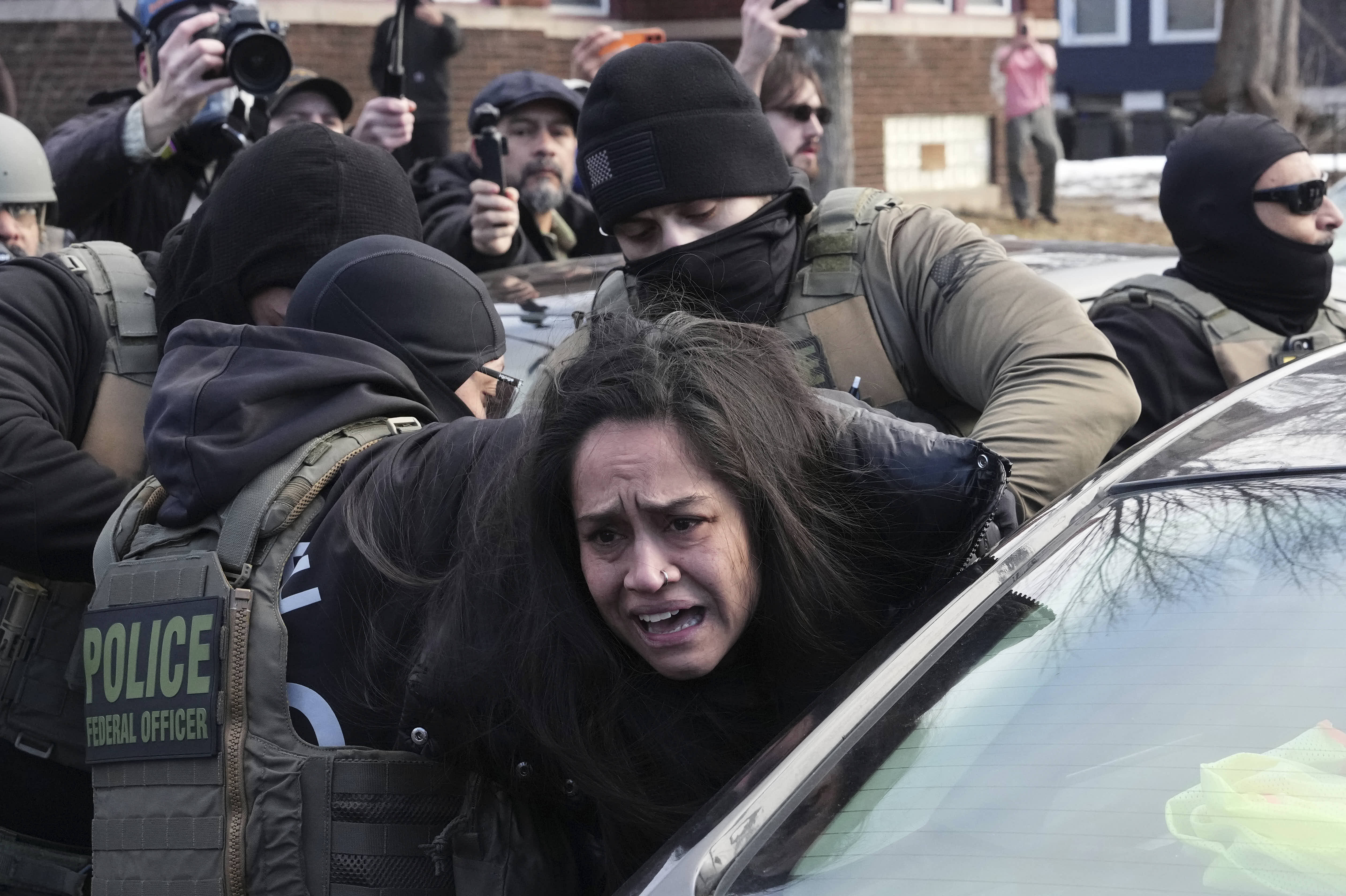 A protester is detained by federal agents near the scene where Renee Good was fatally shot in Minneapolis. 