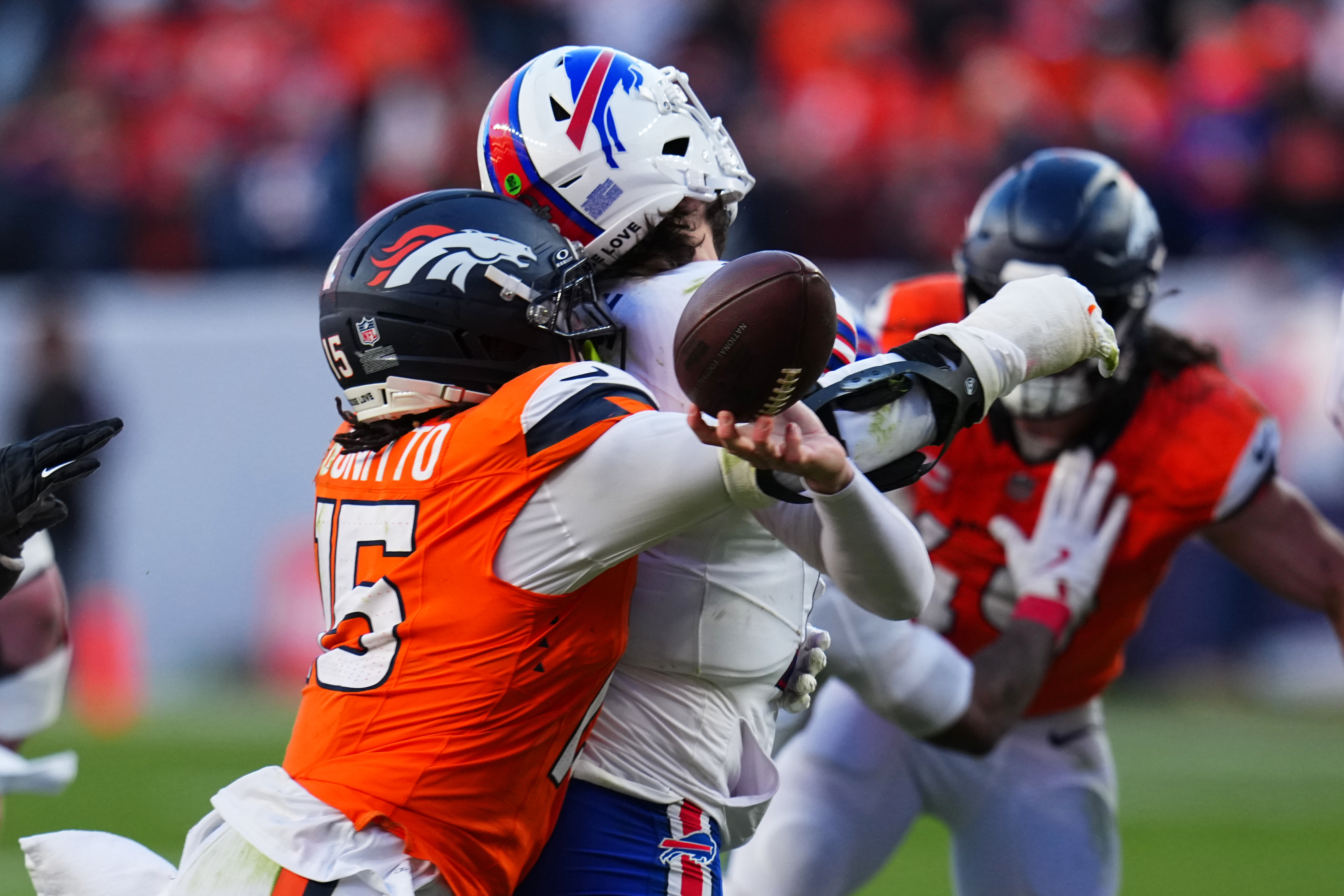 Buffalo Bills quarterback Josh Allen (17) fumbles the ball while being tackled by Denver Broncos linebacker Nik Bonitto (15) during the second half of an NFL divisional round playoff football game, Saturday in Denver. (AP Photo/Jack Dempsey).
