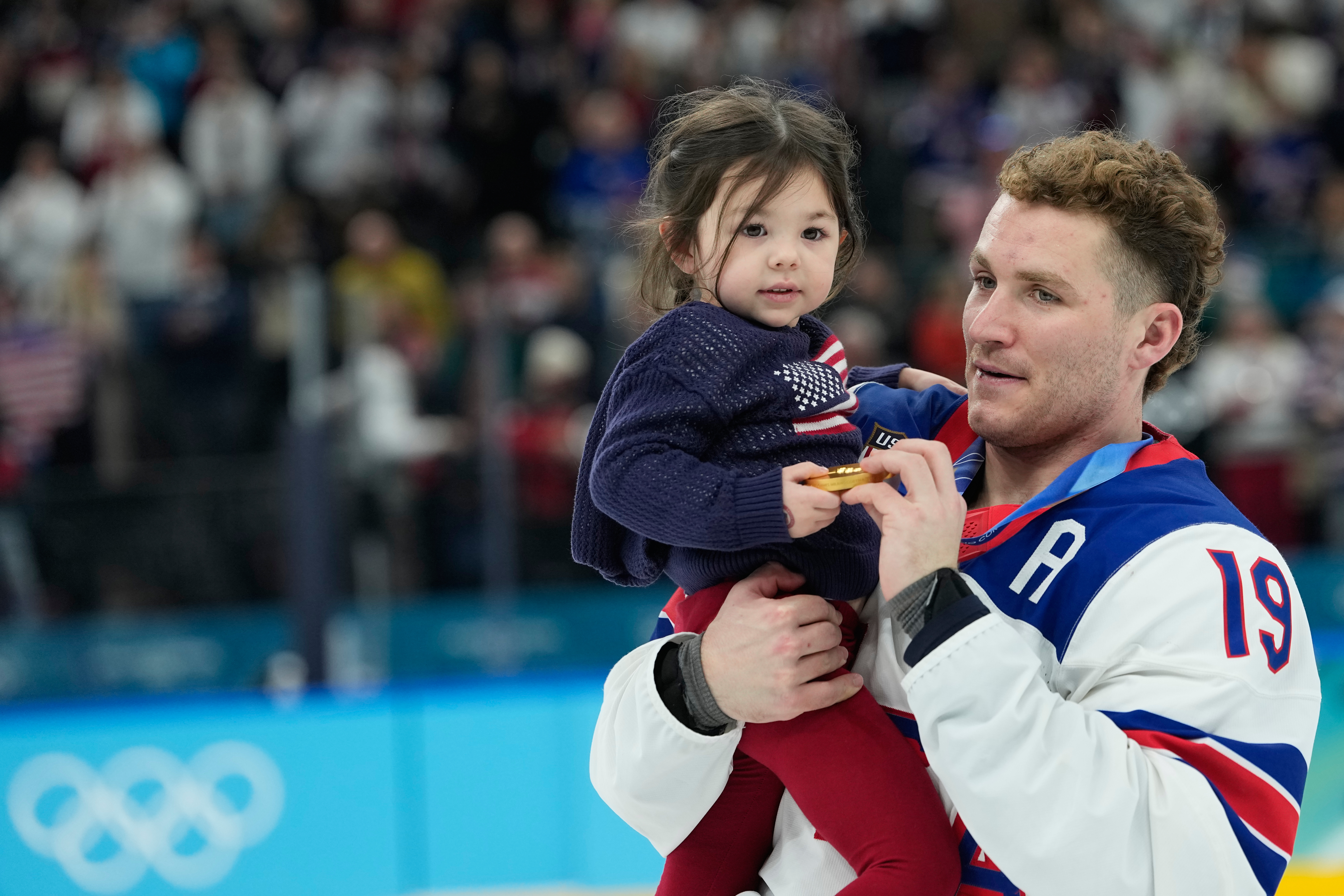 United States' Matthew Tkachuk (19) carries Noa Gaudreau, following a men's ice hockey gold medal game between Canada and the United States at the 2026 Winter Olympics, in Milan, Italy, Sunday, Feb. 22, 2026.