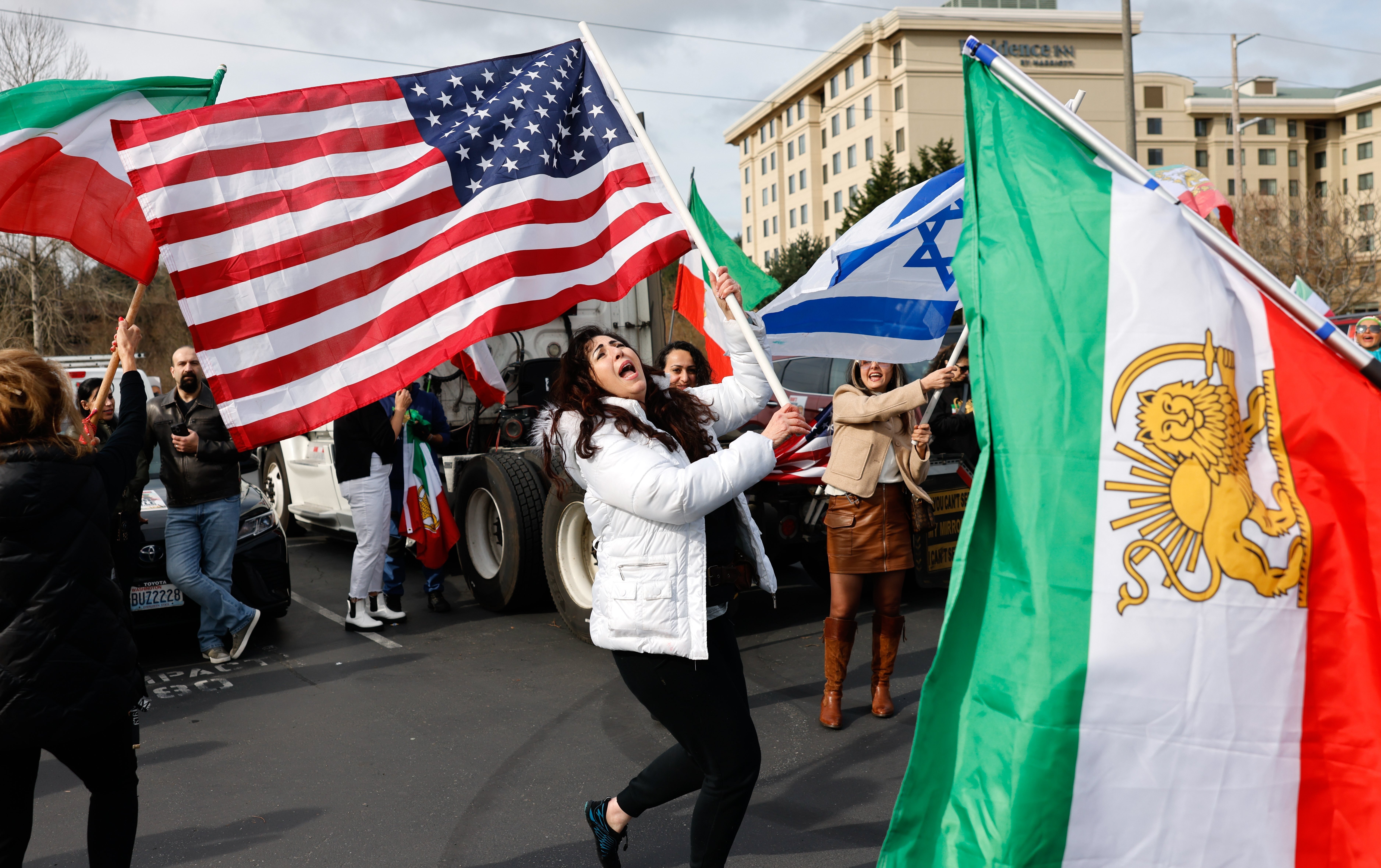 Karla Mohtashemi, center, celebrates as Voice of Iran hosts a car rally in Bellevue, Wash., on Saturday, Feb. 28, 2026, in response to the U.S. bombing of Iran.