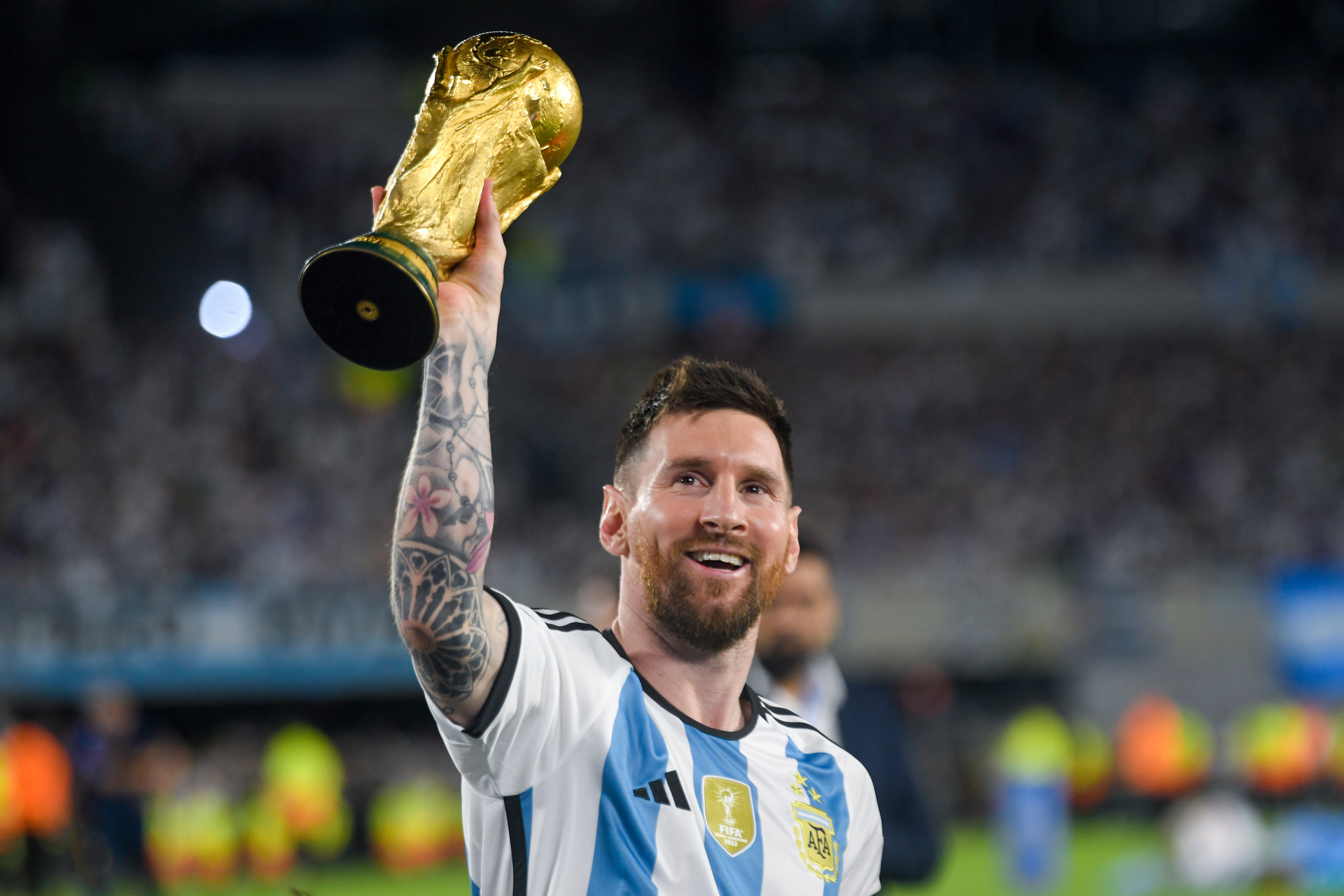 FILE - Argentina's Lionel Messi hoists the winning team replica of the FIFA World Cup trophy during a celebration ceremony for local fans after an international friendly soccer match against Panama at the Monumental stadium in Buenos Aires, Argentina, March 23, 2023.