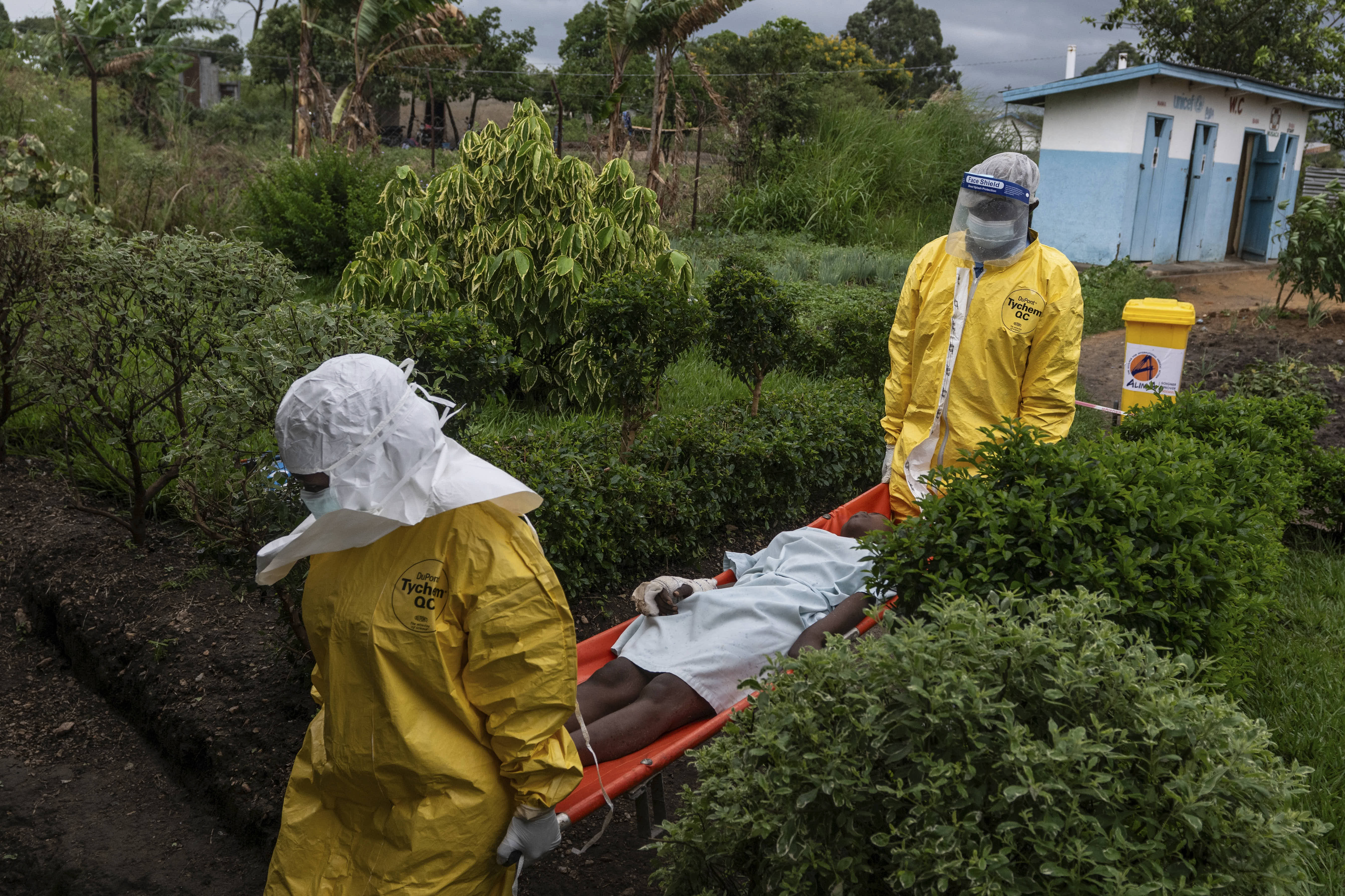 Medical staff carry an Ebola patient to a treatment center in Rwampara.