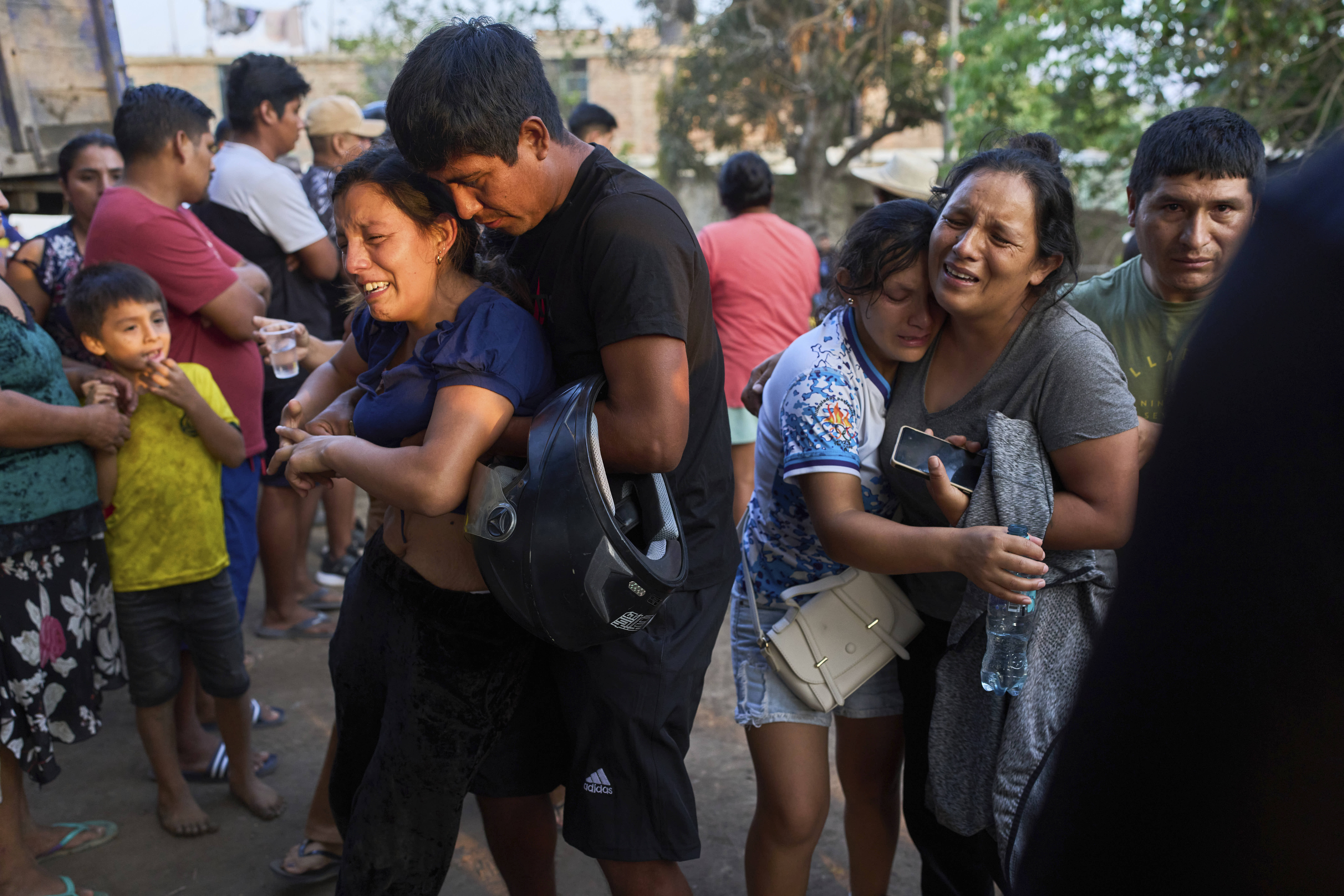 Relatives of Jose Perez mourn as police recover his body from a ravine in Peru.. 