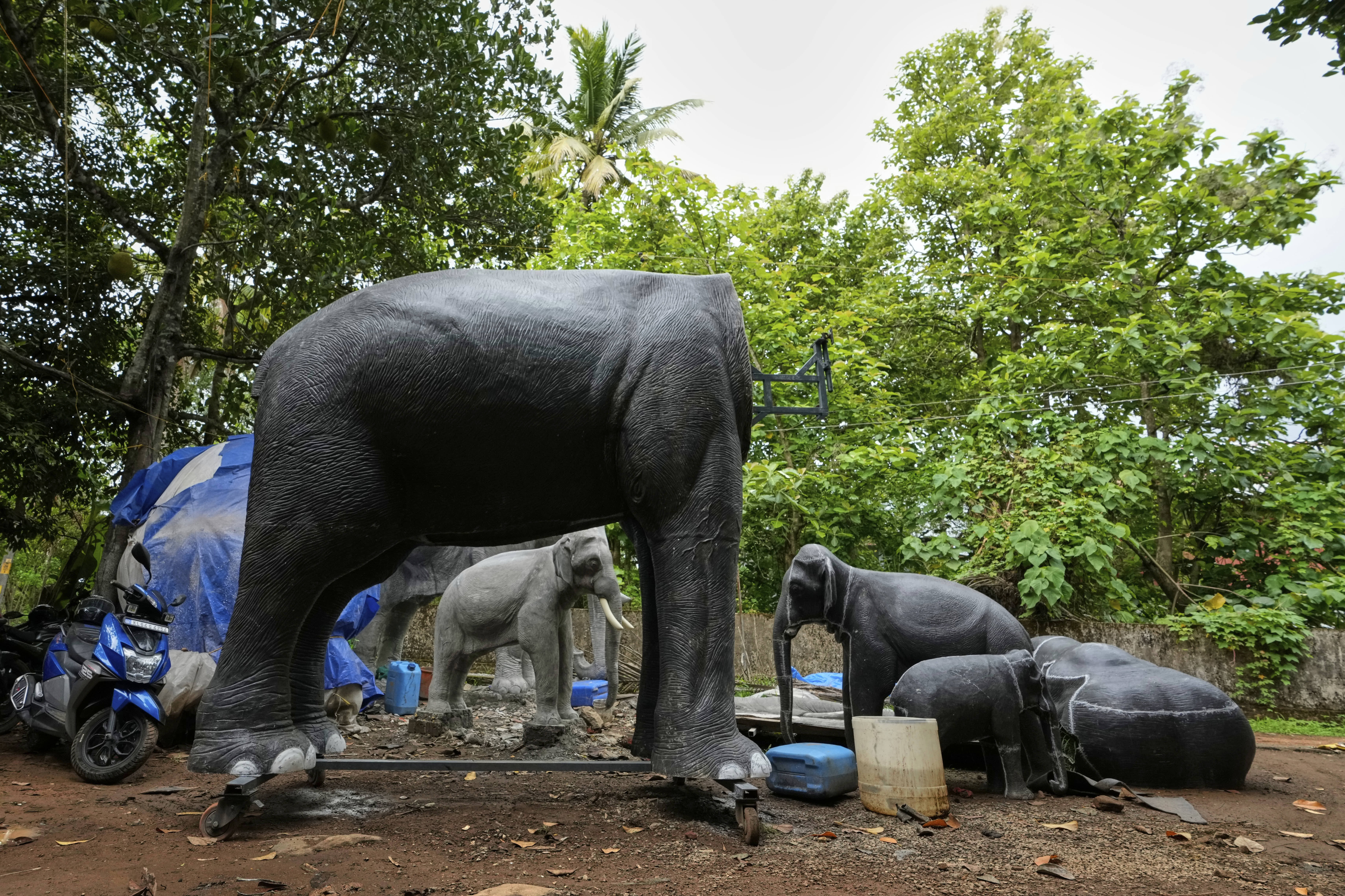 An unfinished robotic elephant stands alongside others at a backyard workshop in Chalakudy, India.