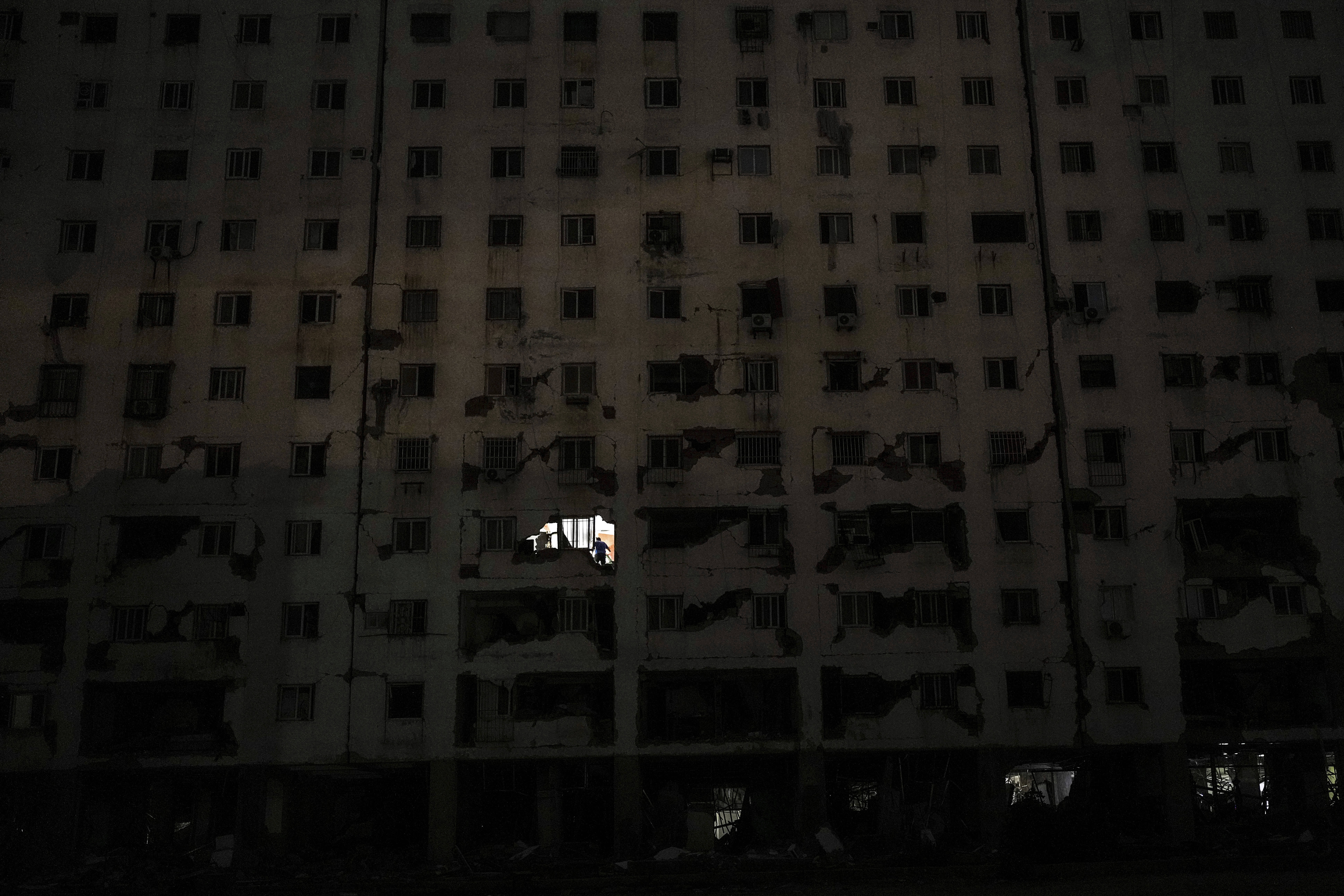 A person stands inside an apartment of an earthquake- damaged building in La Guaira.