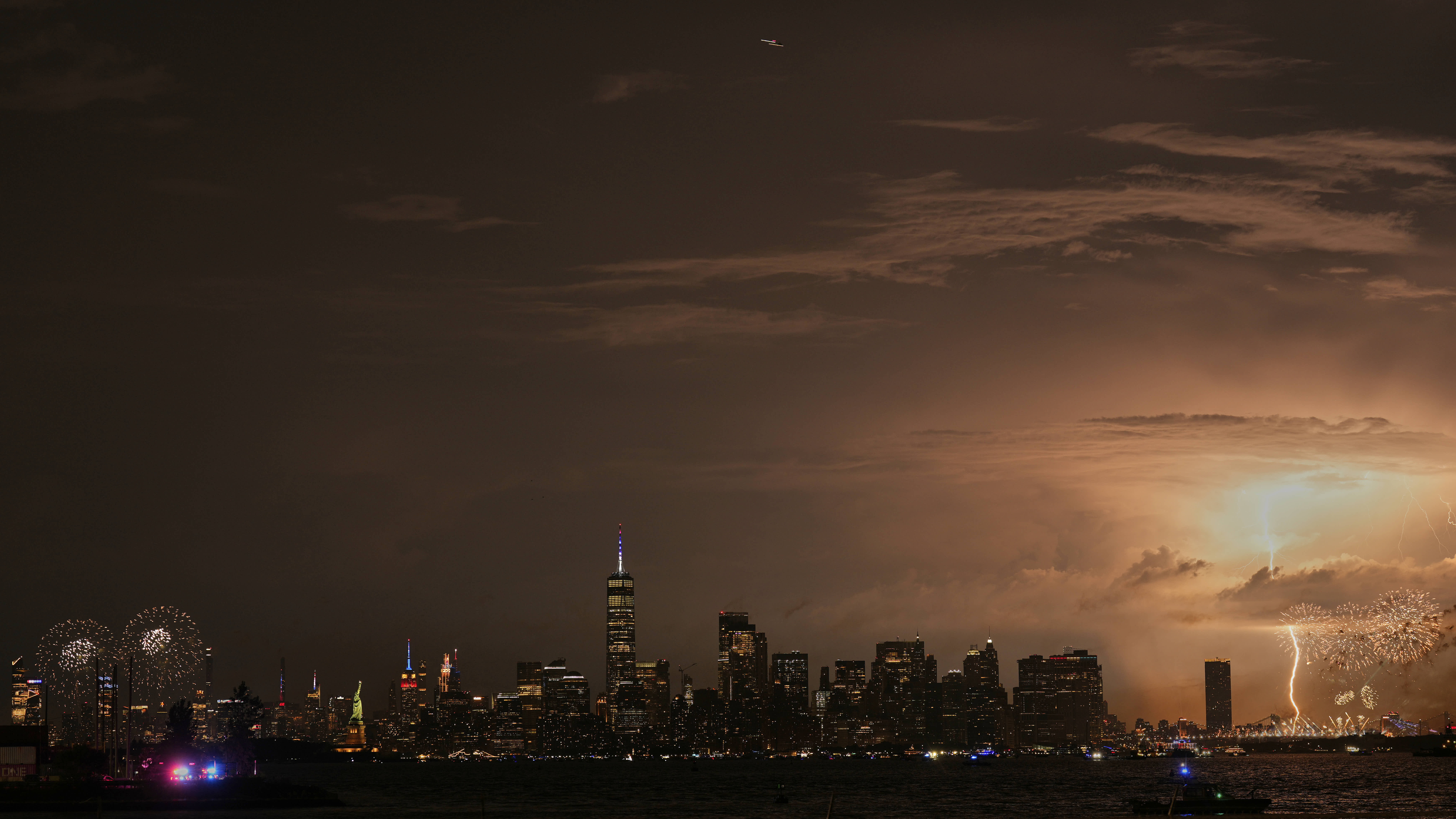 A bolt of lightning strikes during a fireworks show in New York City, as seen from Bayonne, N.J. 