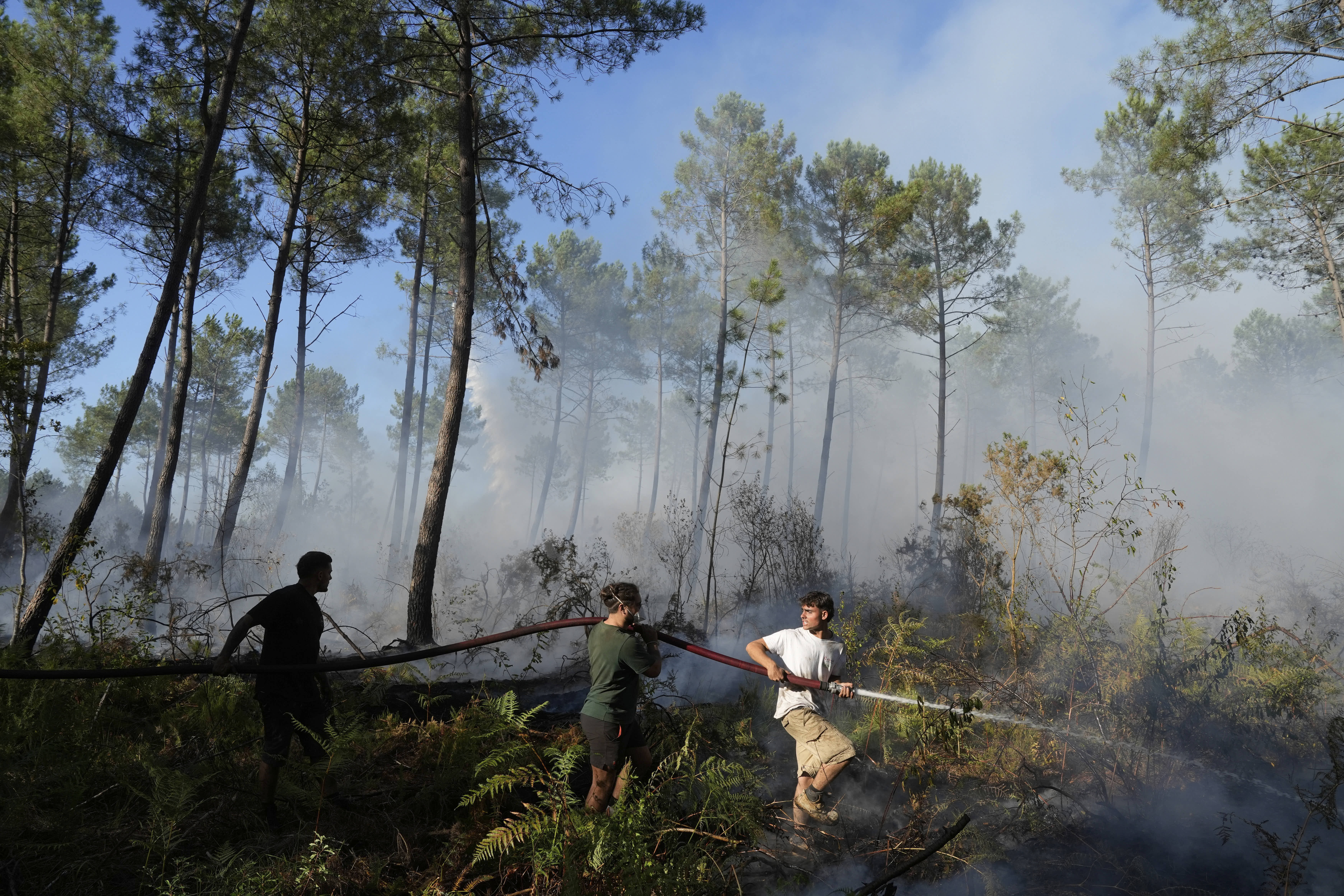 Residents use a firehose to help battle a wildfire in southwestern France.