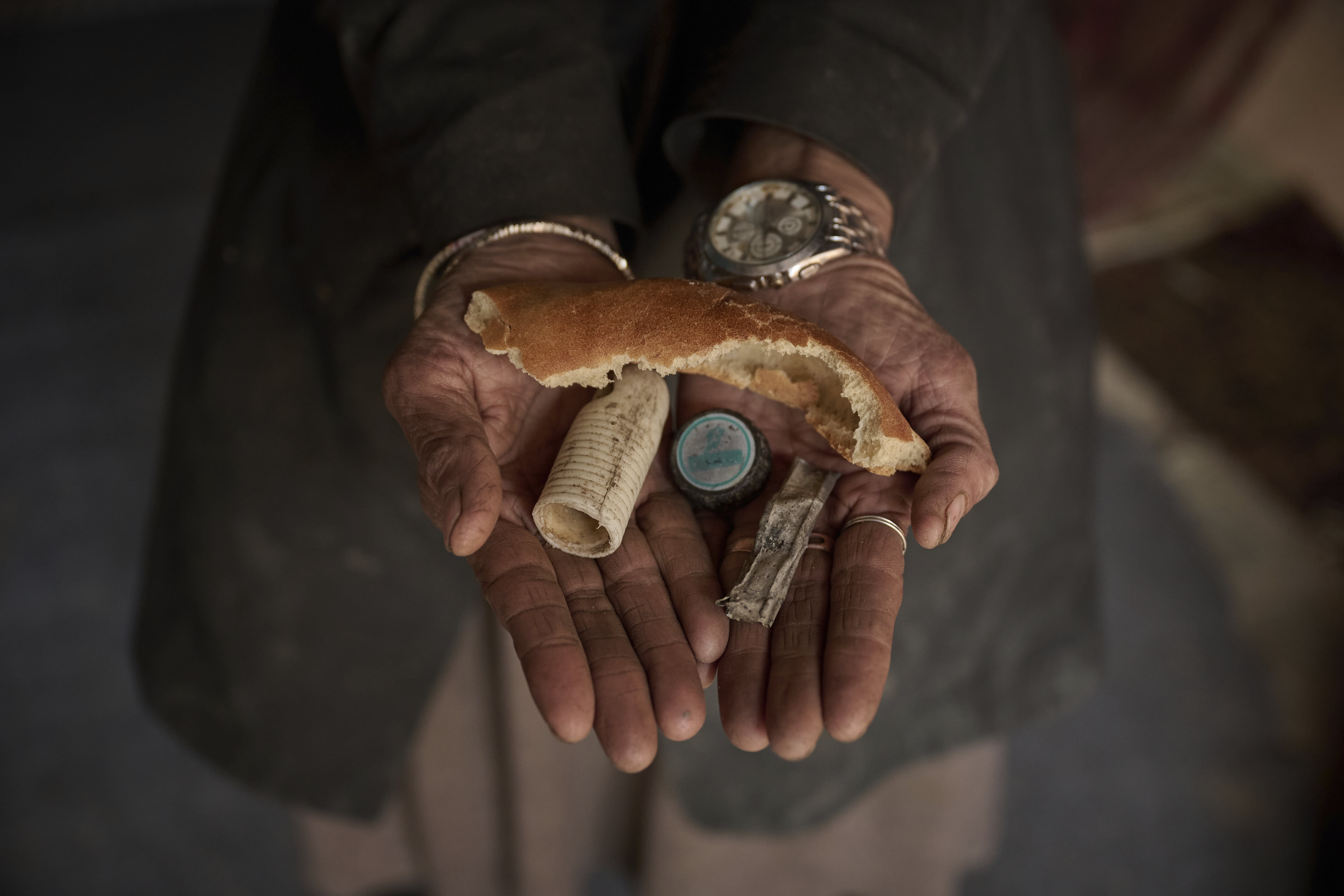 Sima holds discarded items that she collected from the streets in Kabul, Afghanistan. 