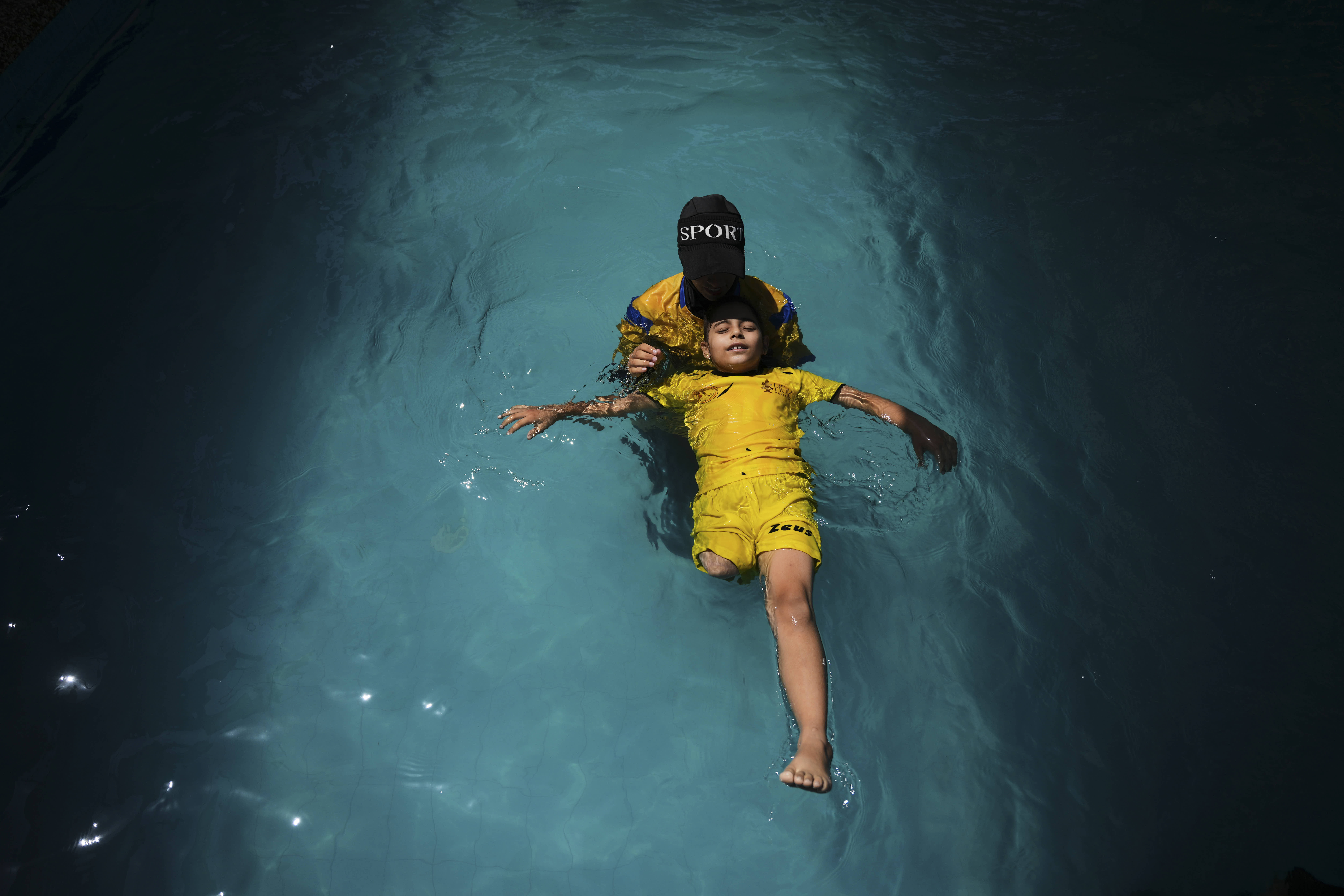 Miral al-Babli, who lost a leg after being injured during the war between Israel and Hamas, receives swimming training in the Gaza Strip.
