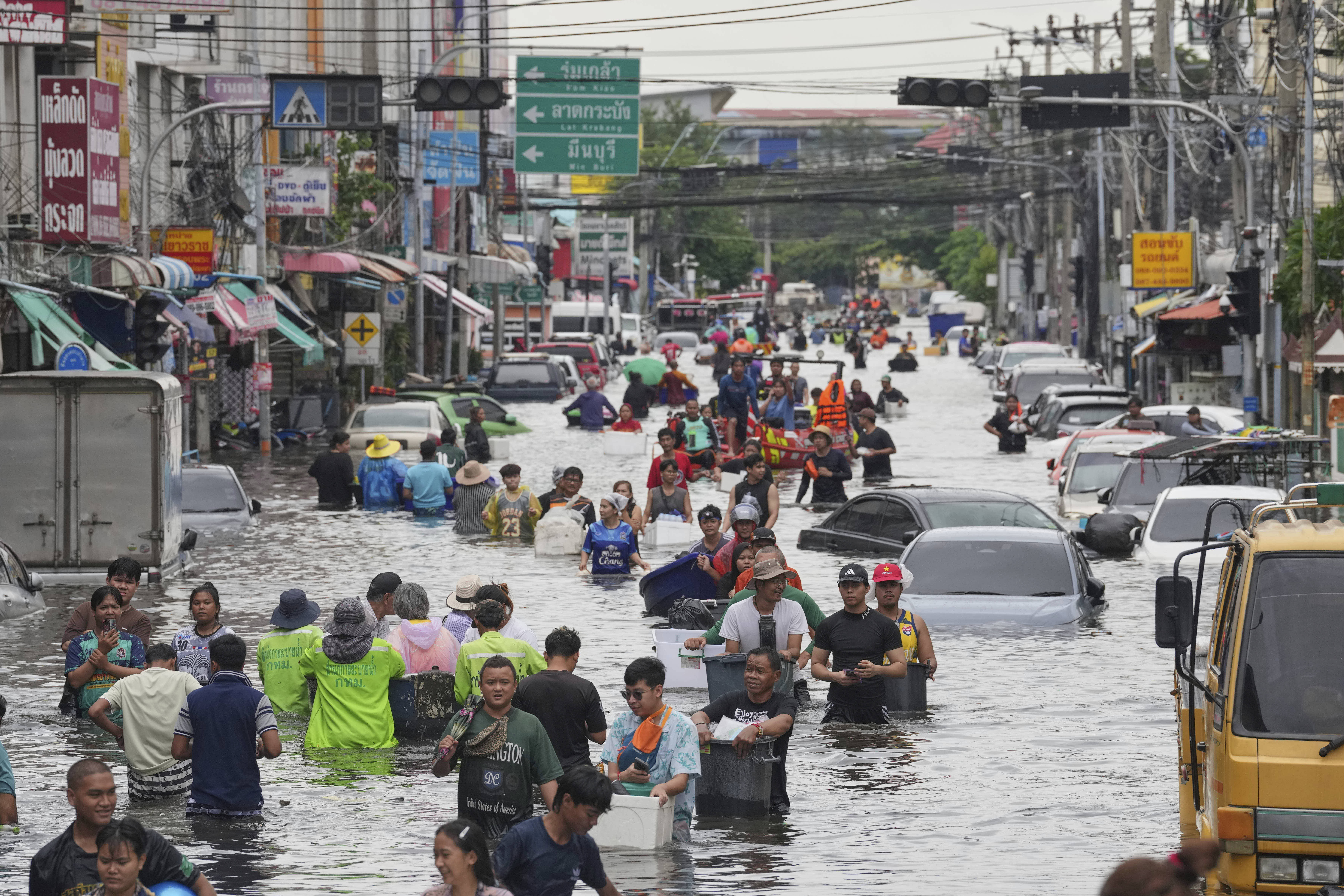 People wade through a flooded street after heavy rain in Bangkok, Thailand.
