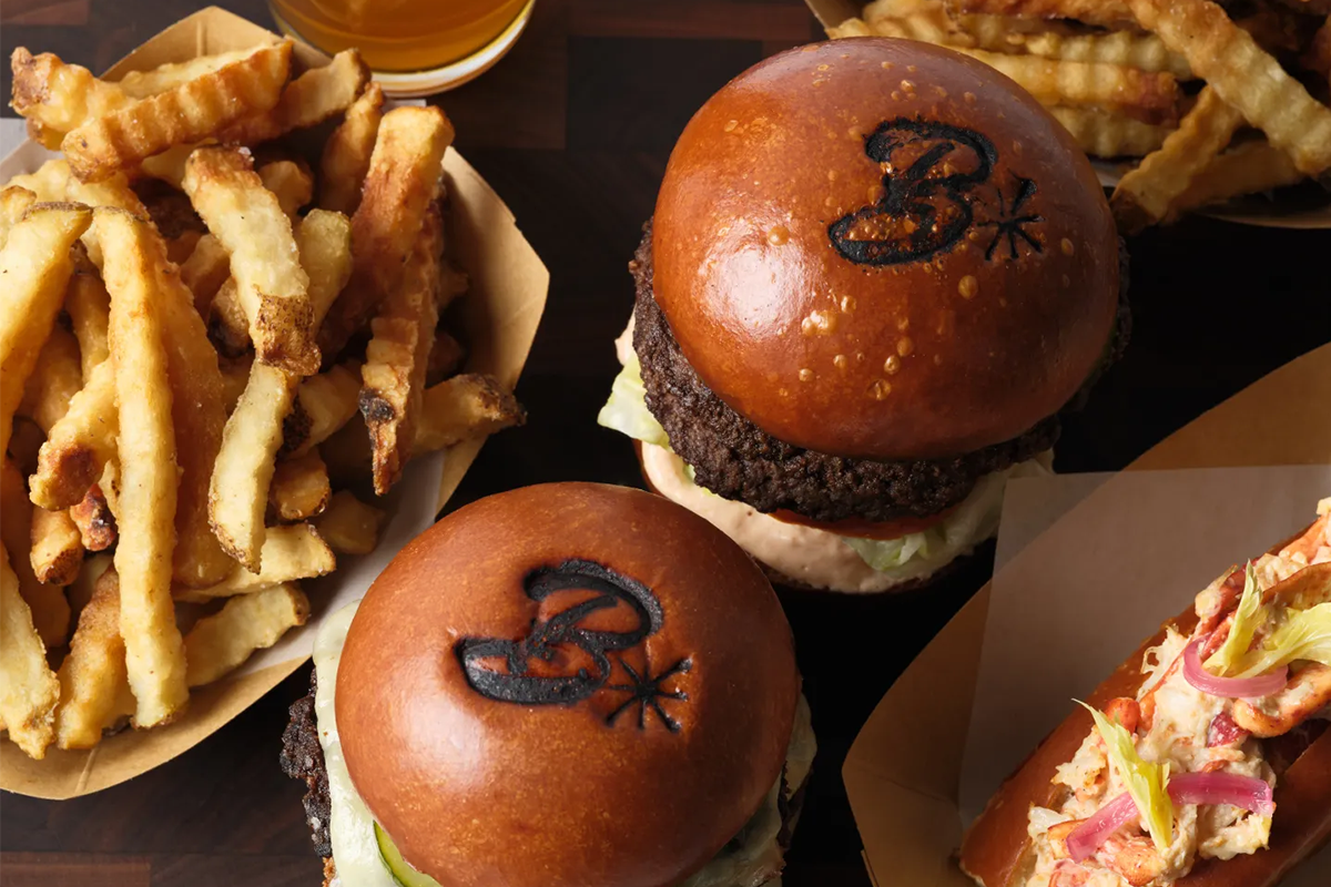 Two burgers, two boats of crinkle fries, a lobster roll, and a pint of beer at Burgers and Half Bottles in Yountville.