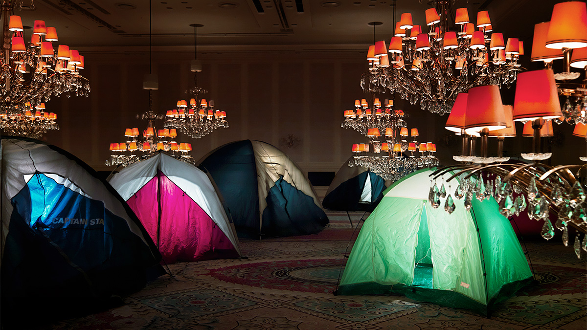 A photo of tents inside a room with chandeliers .