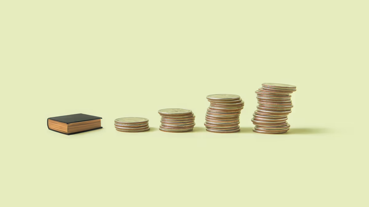 A picture of a book and 4 stacks of coins in ascending order like a chart.